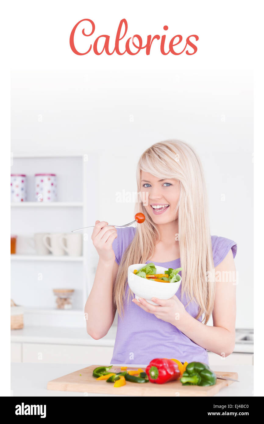 Calories against blonde smiling woman eating her salad Stock Photo