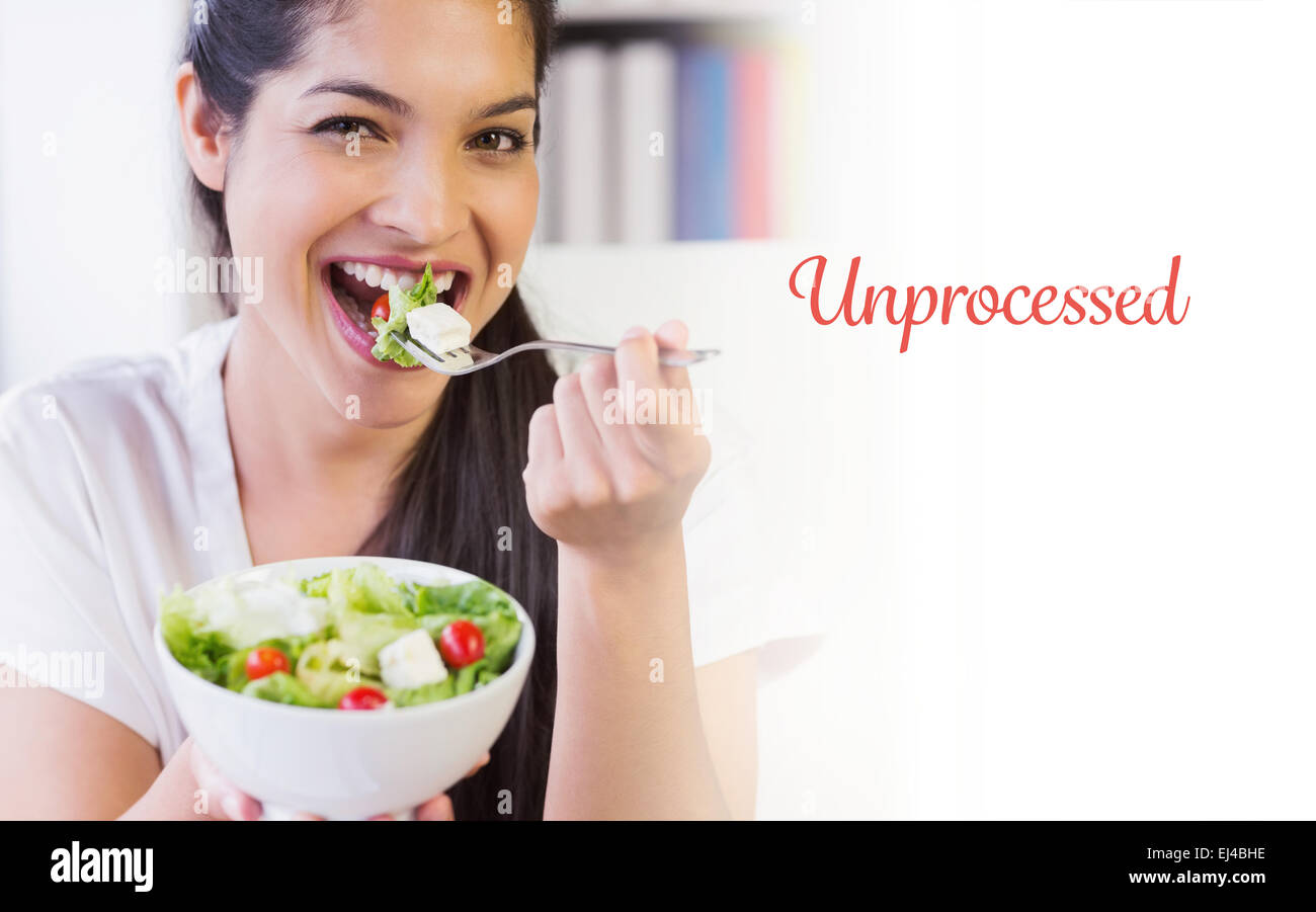 Unprocessed against happy businesswoman eating healthy salad Stock Photo