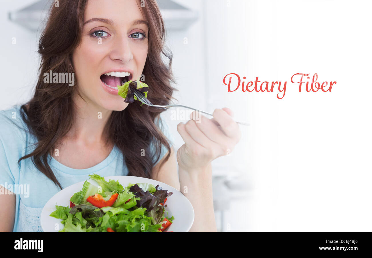 Dietary fiber against brunette eating healthy salad Stock Photo