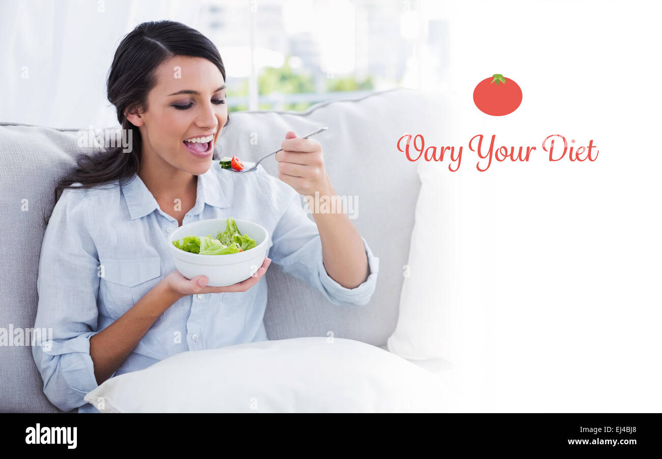 Vary your diet against happy woman relaxing on the sofa eating salad Stock Photo
