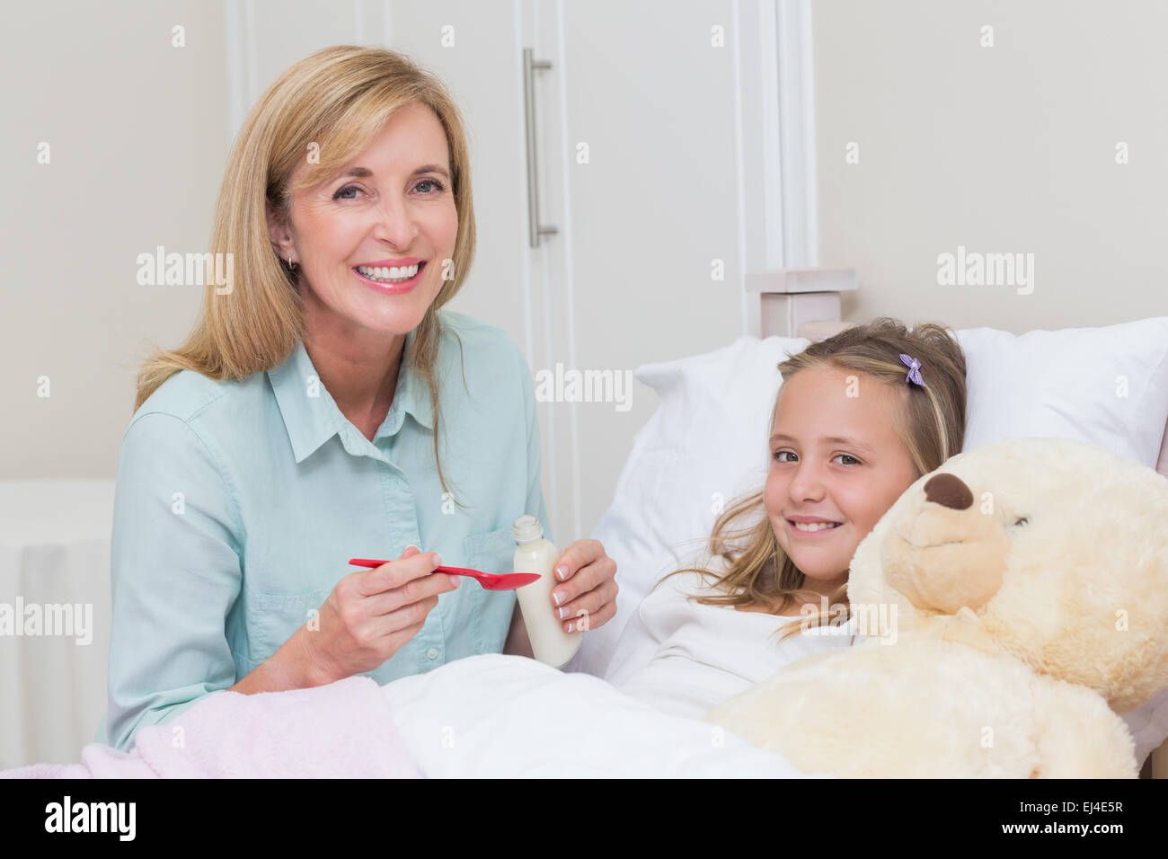 Mother giving her daughter cough medicine Stock Photo Alamy