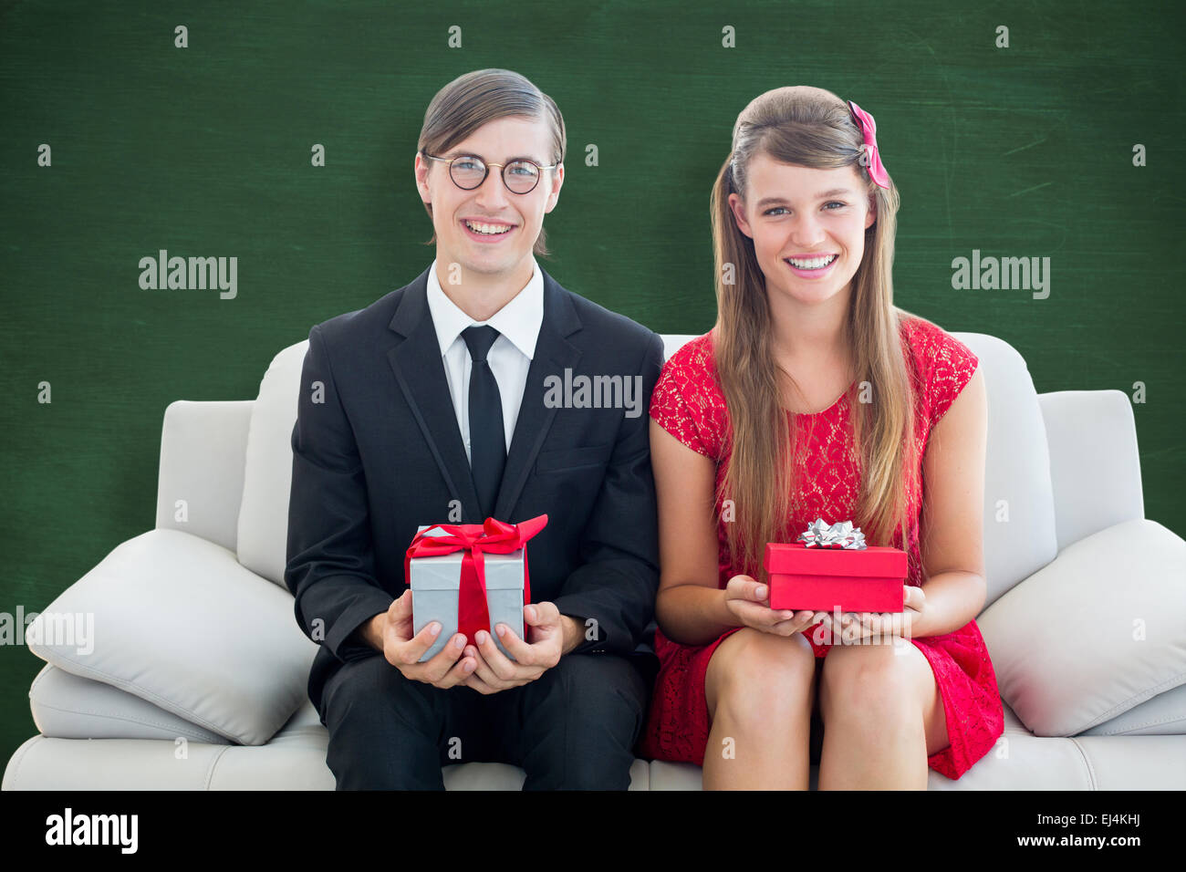 Composite image of cute geeky couple smiling and holding gift Stock ...