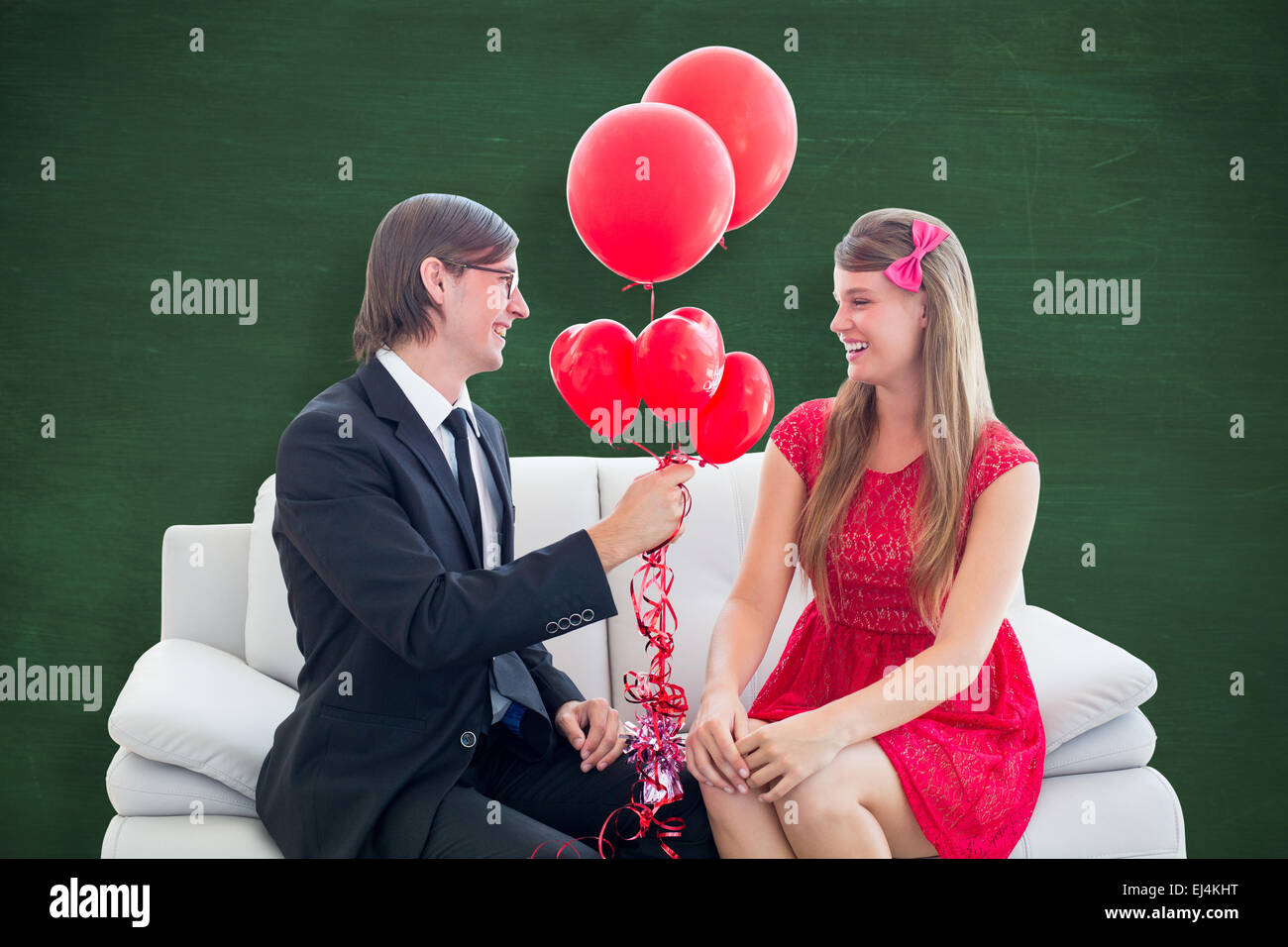 Composite image of cute geeky couple with red balloons Stock Photo - Alamy