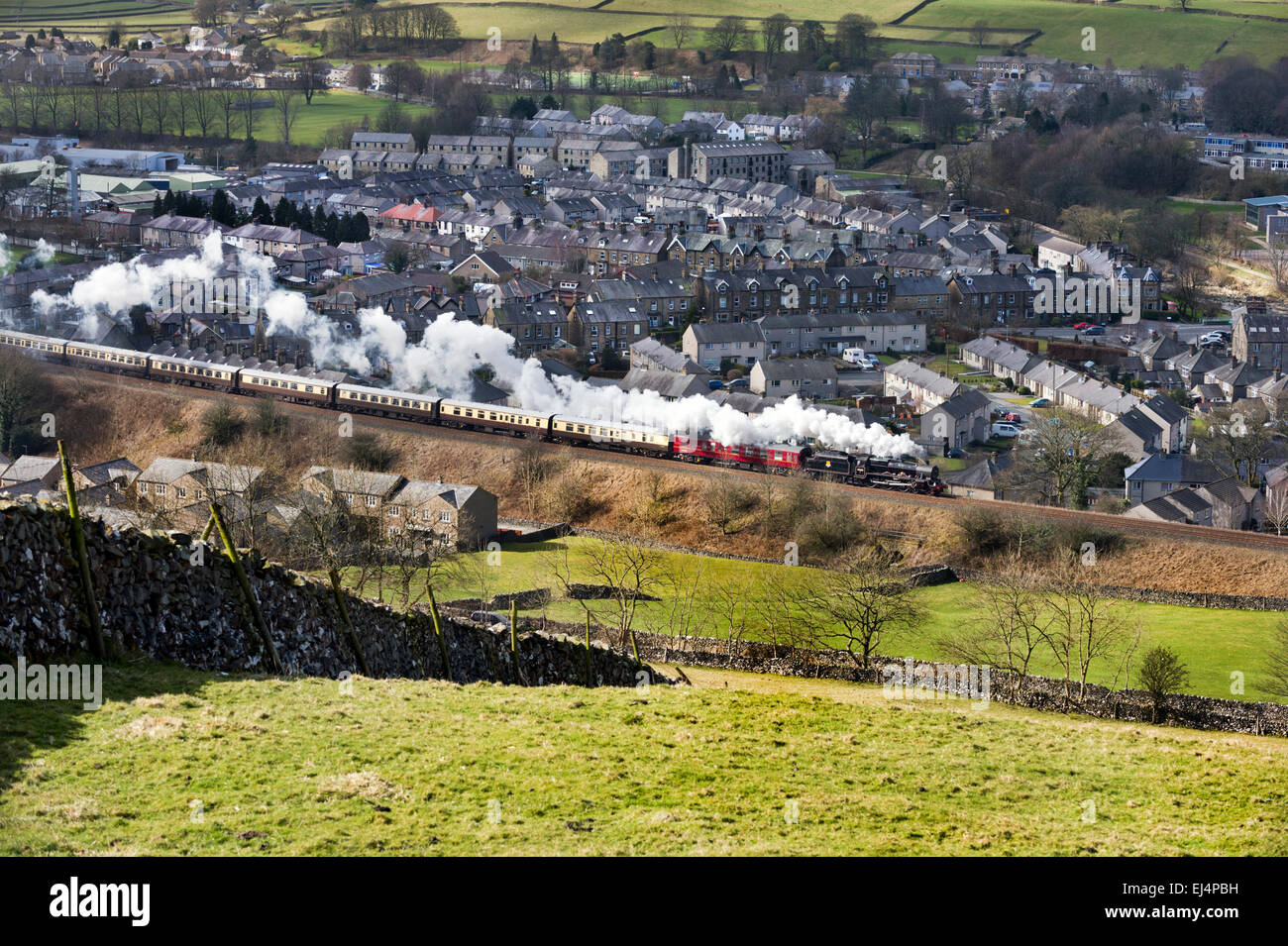 Settle, North Yorkshire, UK. 21st March, 2015. The Cumbrian Jubilee steam special passes through the  Yorkshire Dales town of Settle on its way to Carlisle on a sunny Spring morning. Stock Photo