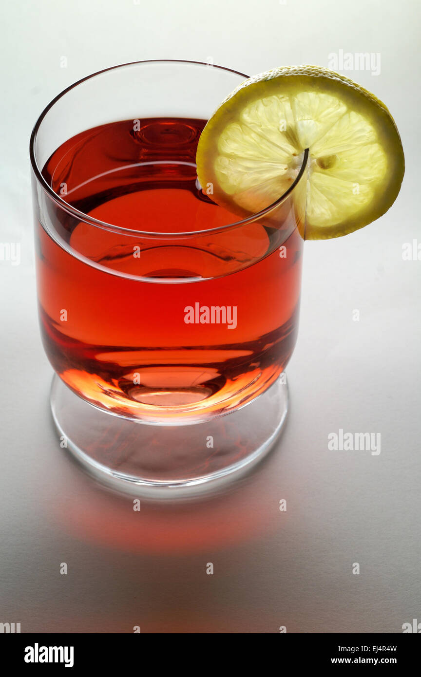 Glass of red liquid ( wine,  tea, etc. ) with lemon slice (vertical) Stock Photo