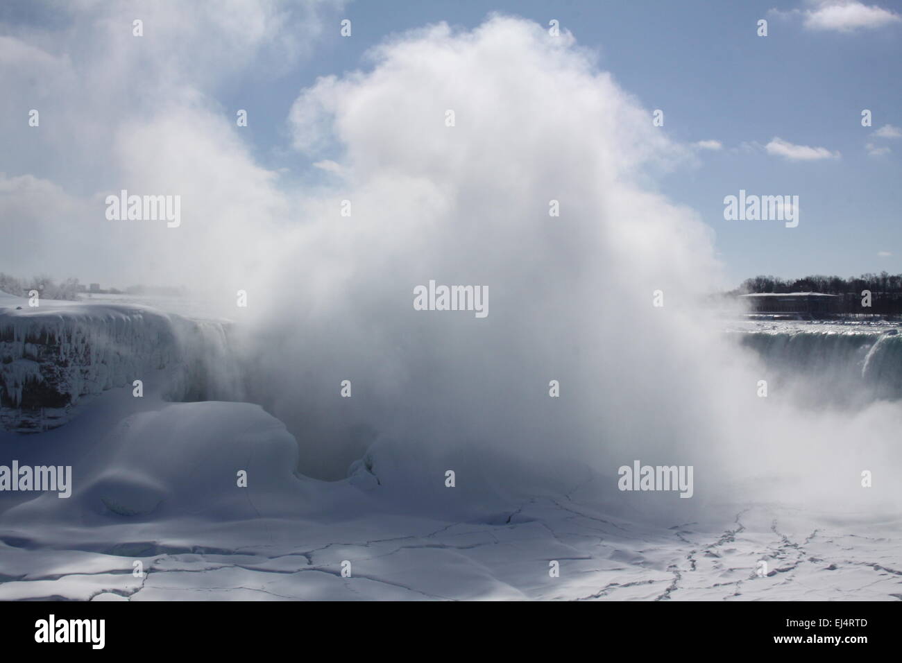 Horseshoe Falls at Niagara Falls, mist rising, during winter months. Ice formed above, below, and beside rushing waters Stock Photo