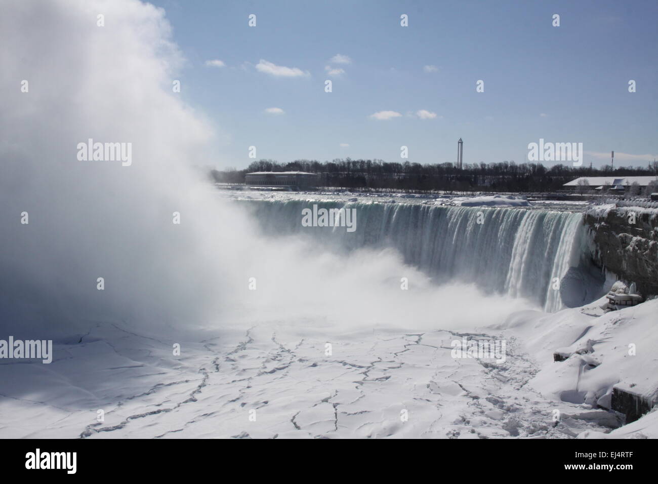 Horseshoe Falls at Niagara Falls, mist rising, during winter months. Ice formed above, below, and beside rushing waters. Stock Photo