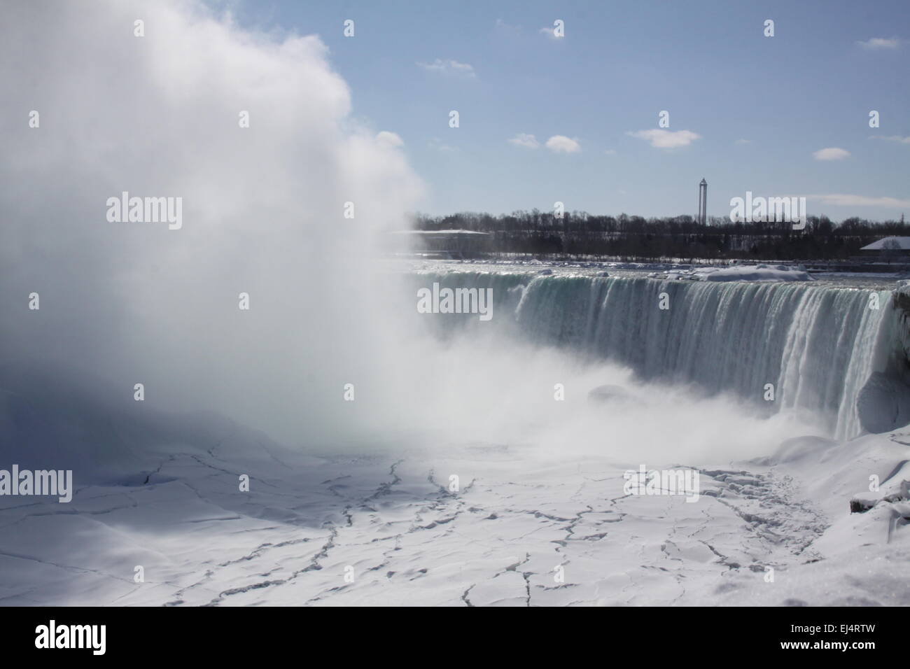 Horseshoe Falls at Niagara Falls, mist rising, during winter months. Ice formed above, below, and beside rushing waters. Stock Photo