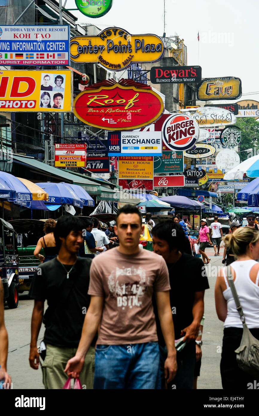 Bangkok, Thailand. Tourists walking underneath advertising hoardings. Stock Photo