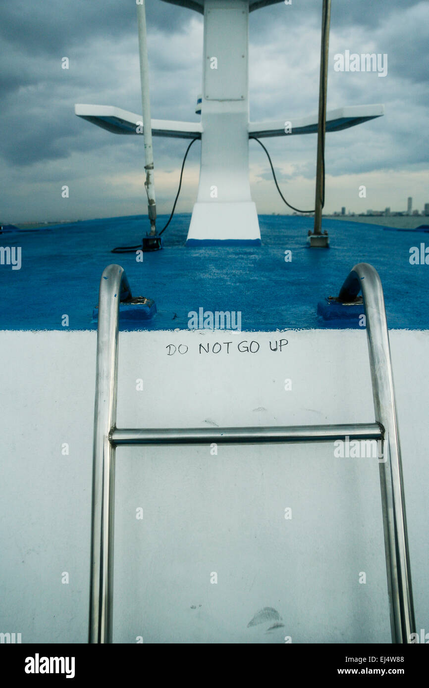 Langkwai, Malaysia. Handwritten 'Do not go up' sign warning passengers not to climb on a ferry's radar assembly. Stock Photo