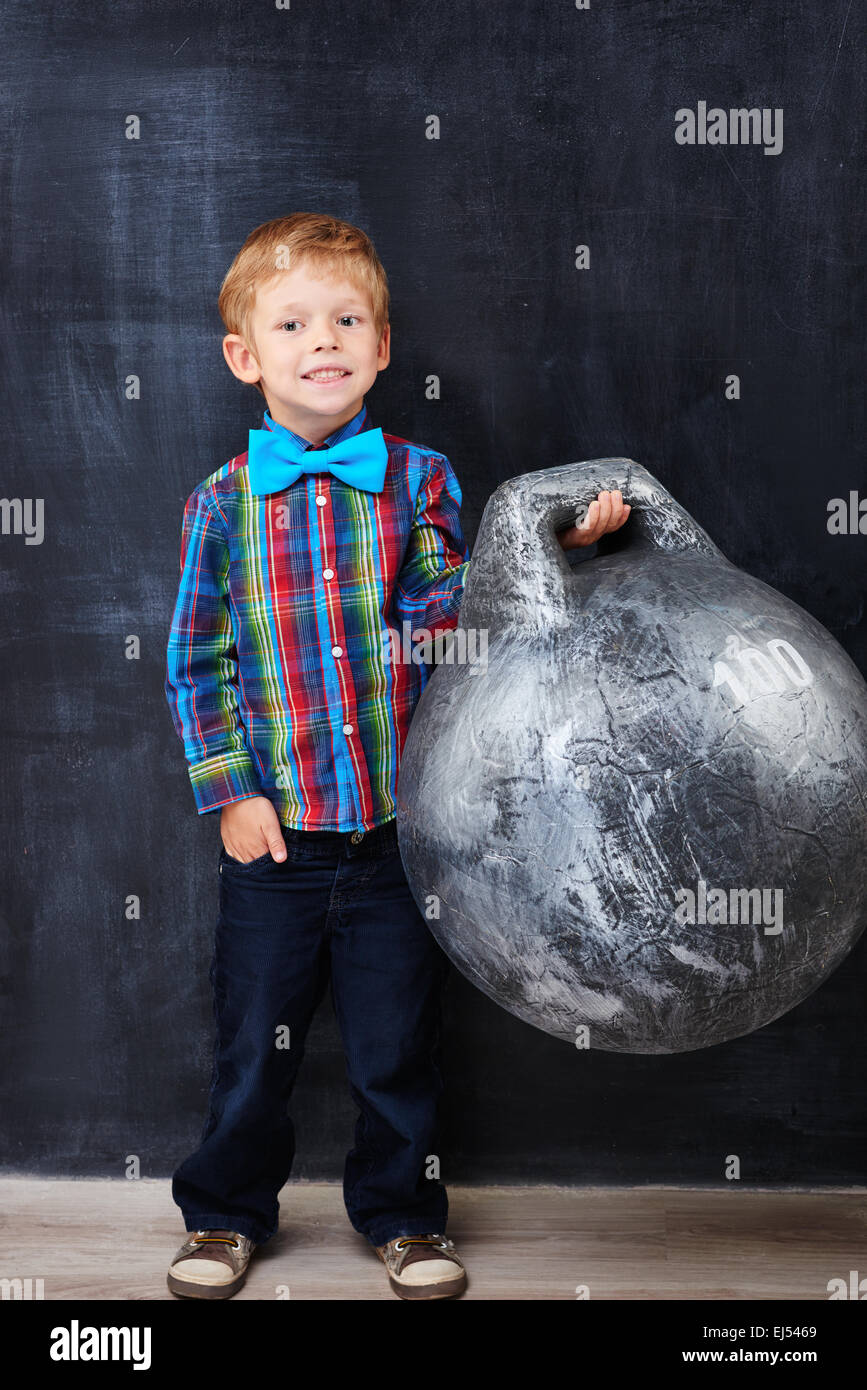 Smiling encoureged redhead school-boy holding huge weight Stock Photo