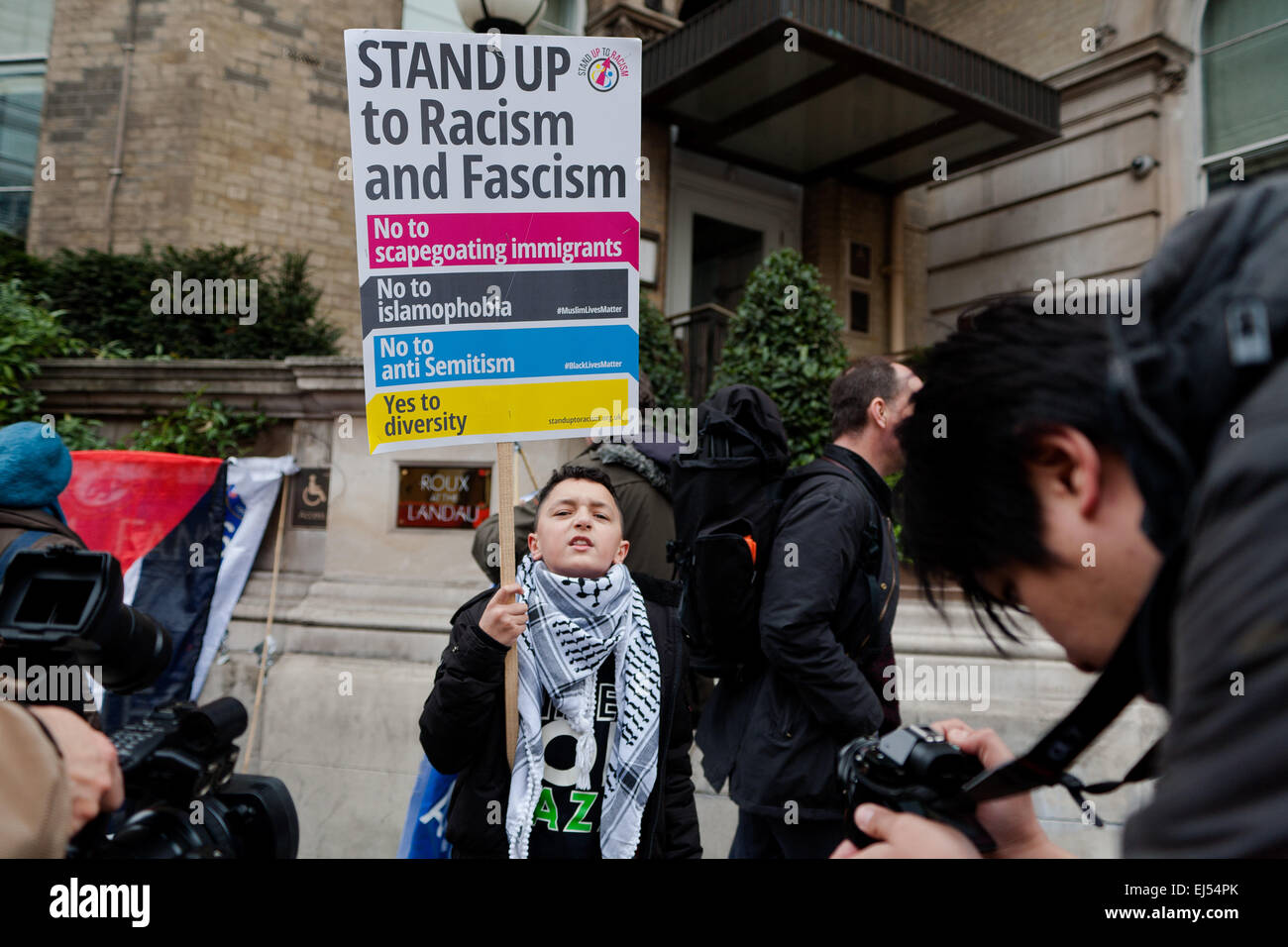 London, UK. 21st March, 2015.  Young protester standing with a placard that reads 'Stand up to racism and fascisml' at the Stand up to racism and fascism Protest London,  Credit:  Peter Barbe/Alamy Live News Stock Photo