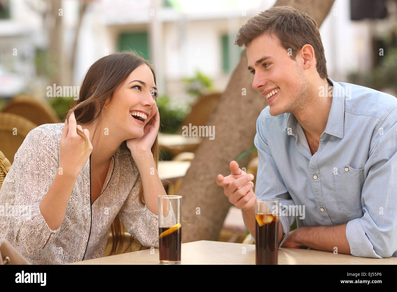 Couple dating and flirting while taking a conversation and looking each other in a restaurant Stock Photo