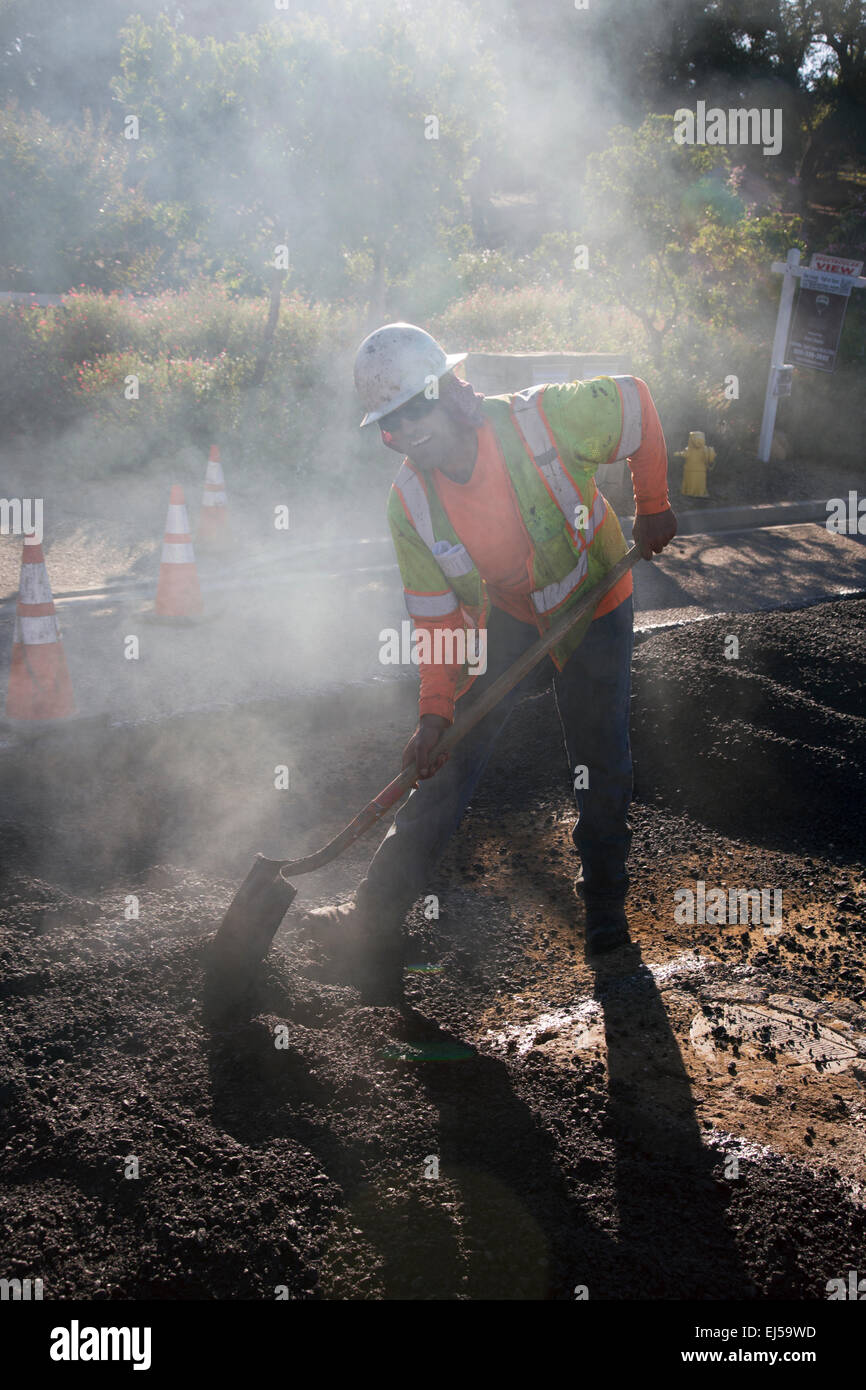 Roadworker repaves road with steam, Encino Drive, Oak View, California, USA Stock Photo