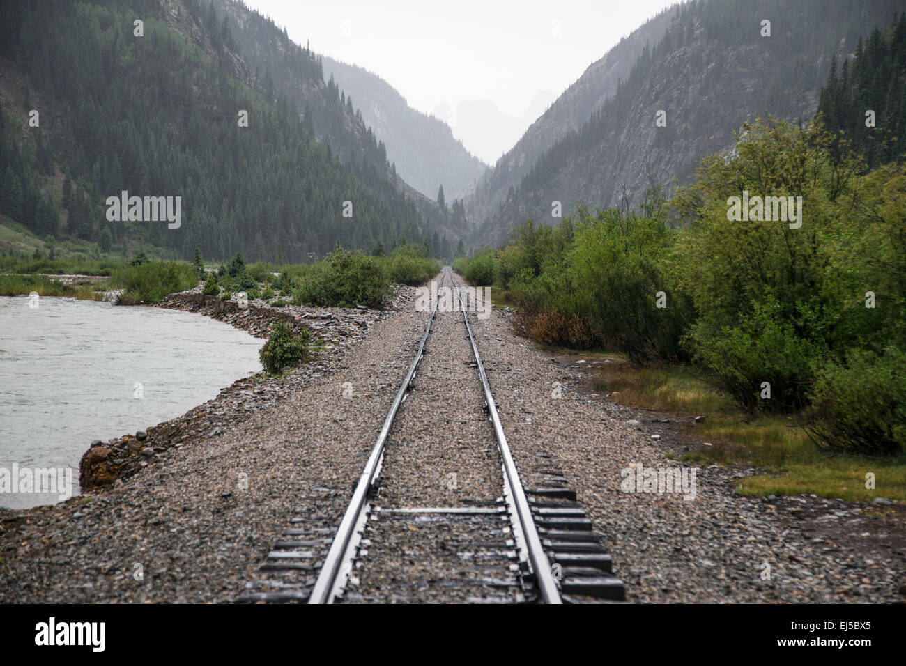 Raid Road tracks towards mountains and Animas River, Durango and Silverton Narrow Gauge Railroad, Silverton, Colorado, USA Stock Photo