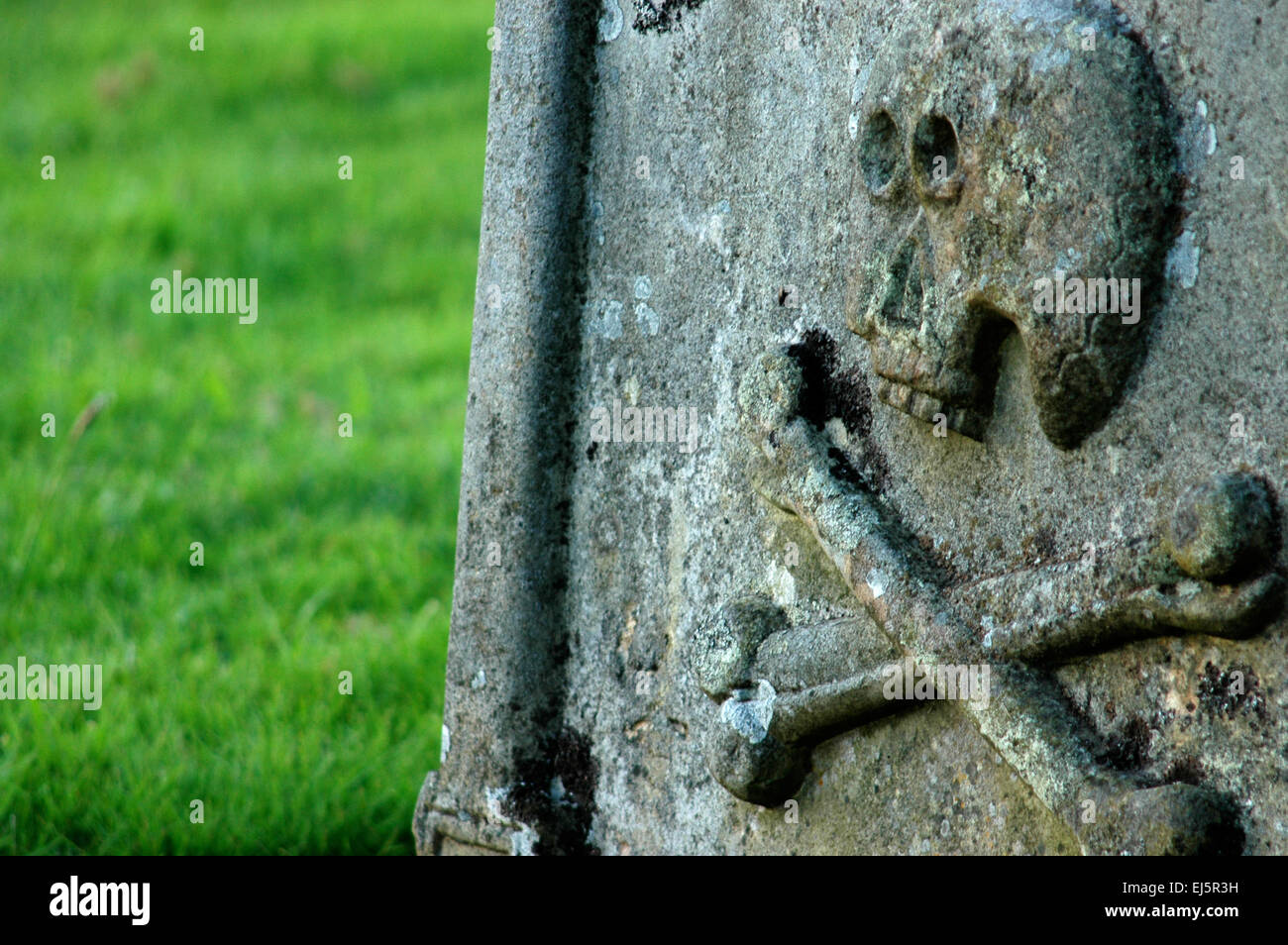 An ancient gravestone with a skull and crossbones Stock Photo Alamy