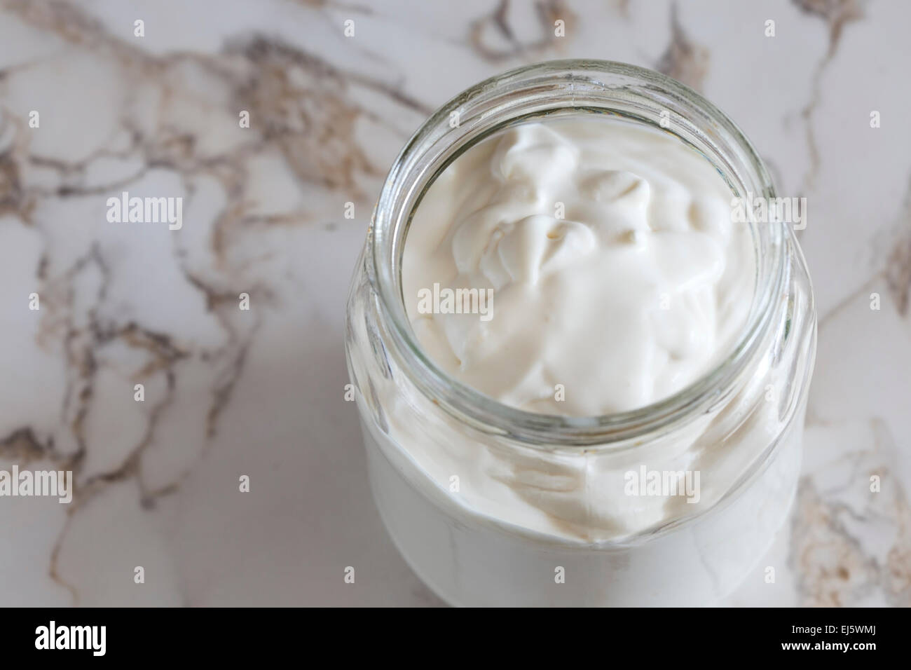 Close up of one jar with cream on kitchen table Stock Photo