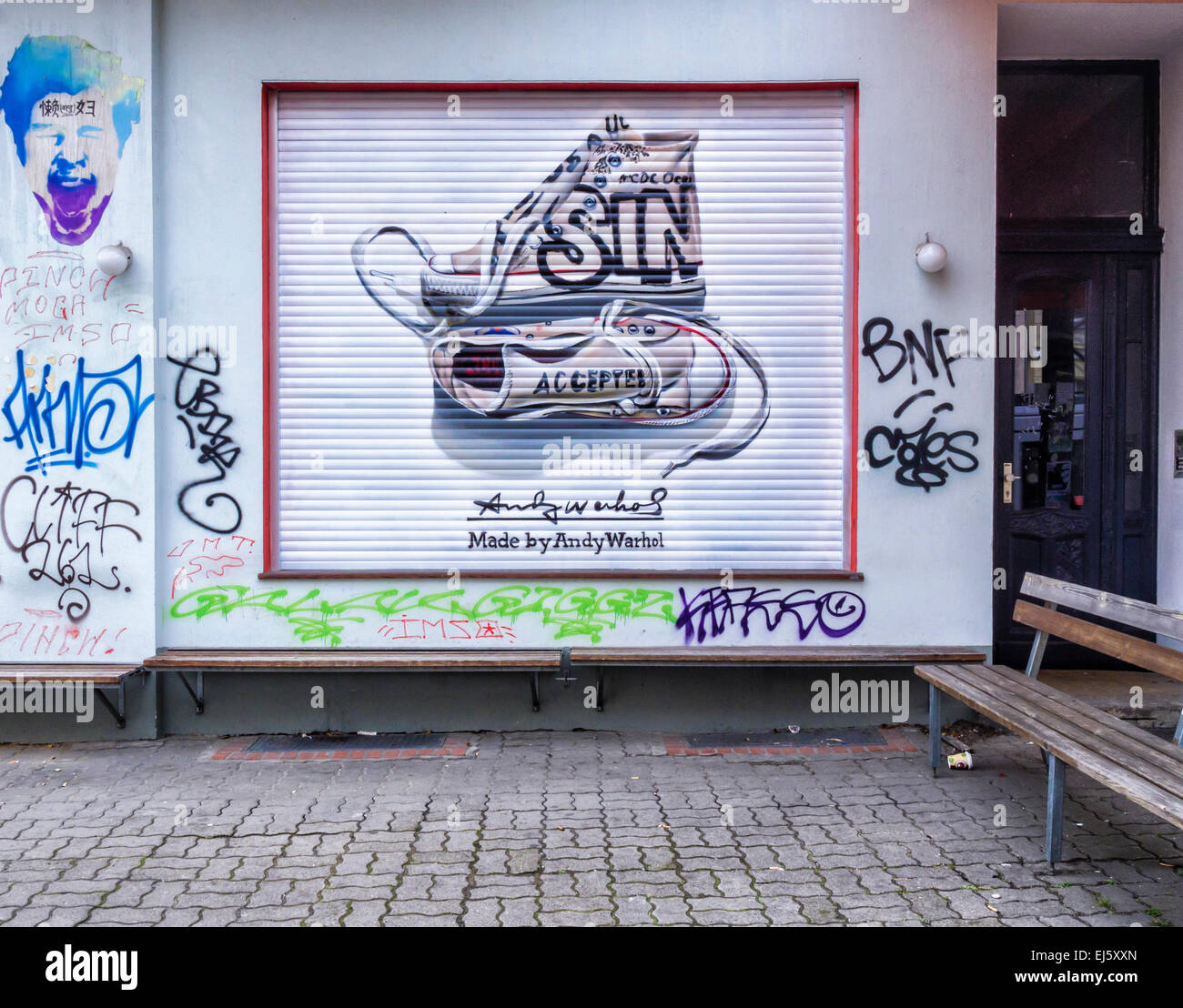 Advertisement for Converse trainers, chucks named after Chuck Taylor  amongst graffiti on shop blind, Mitte Berlin Stock Photo - Alamy
