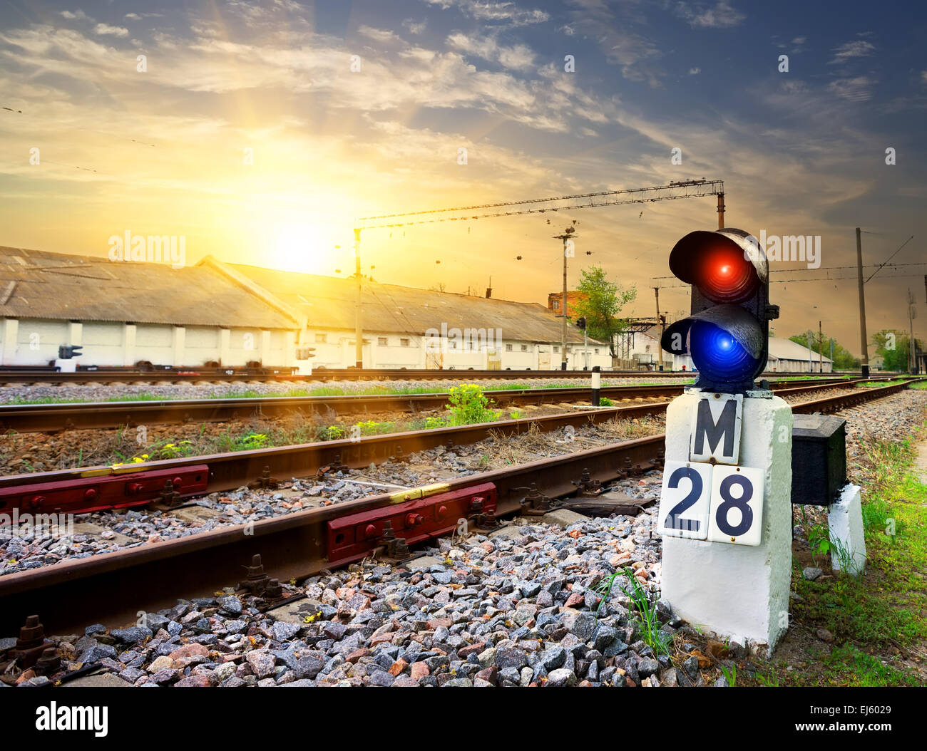 Railway semaphore near industrial station at sunset Stock Photo