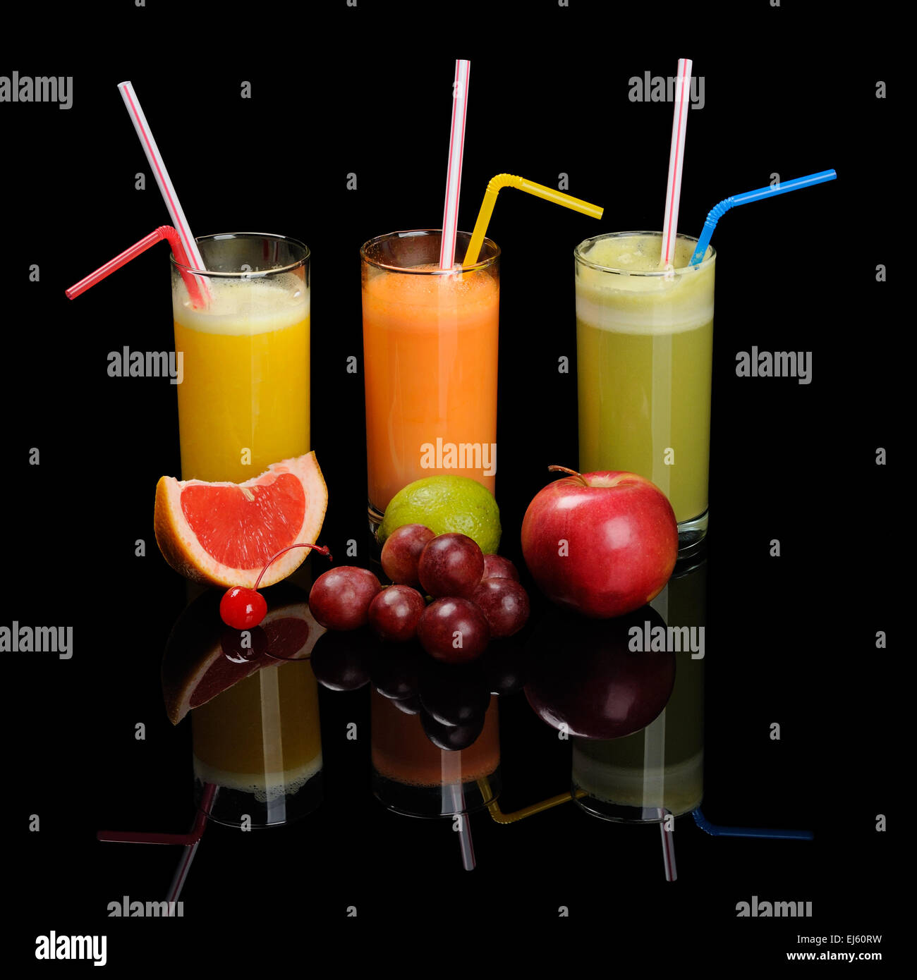 Orange, carrot and green apple juices on black Stock Photo