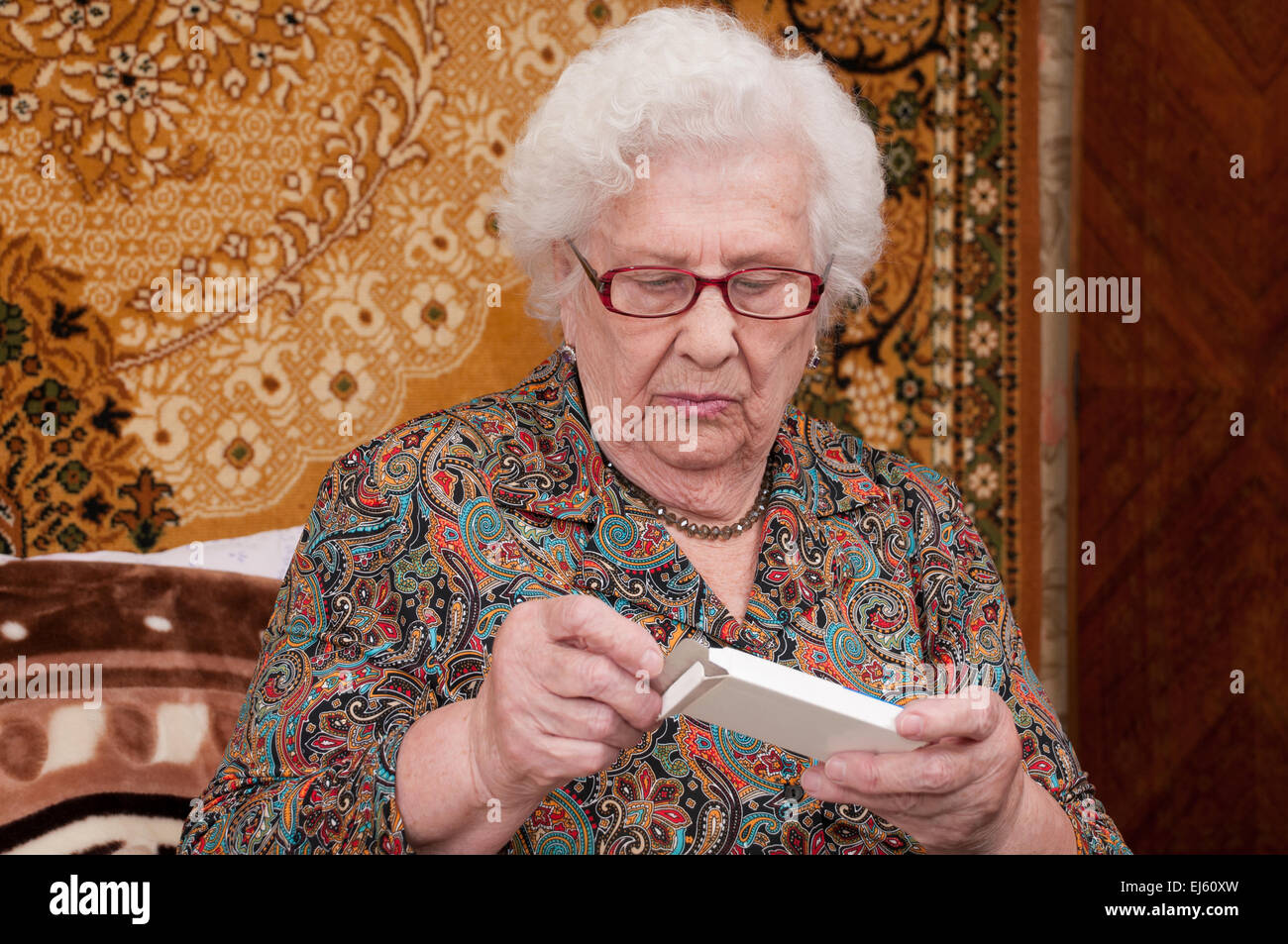 Senior woman reads prescriptions and takes out pills Stock Photo