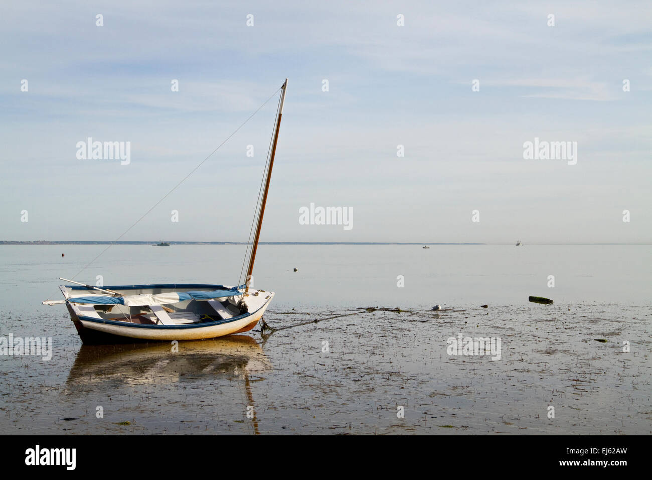 Sailboat with reflections on beautiful beach at low tide. Provincetown