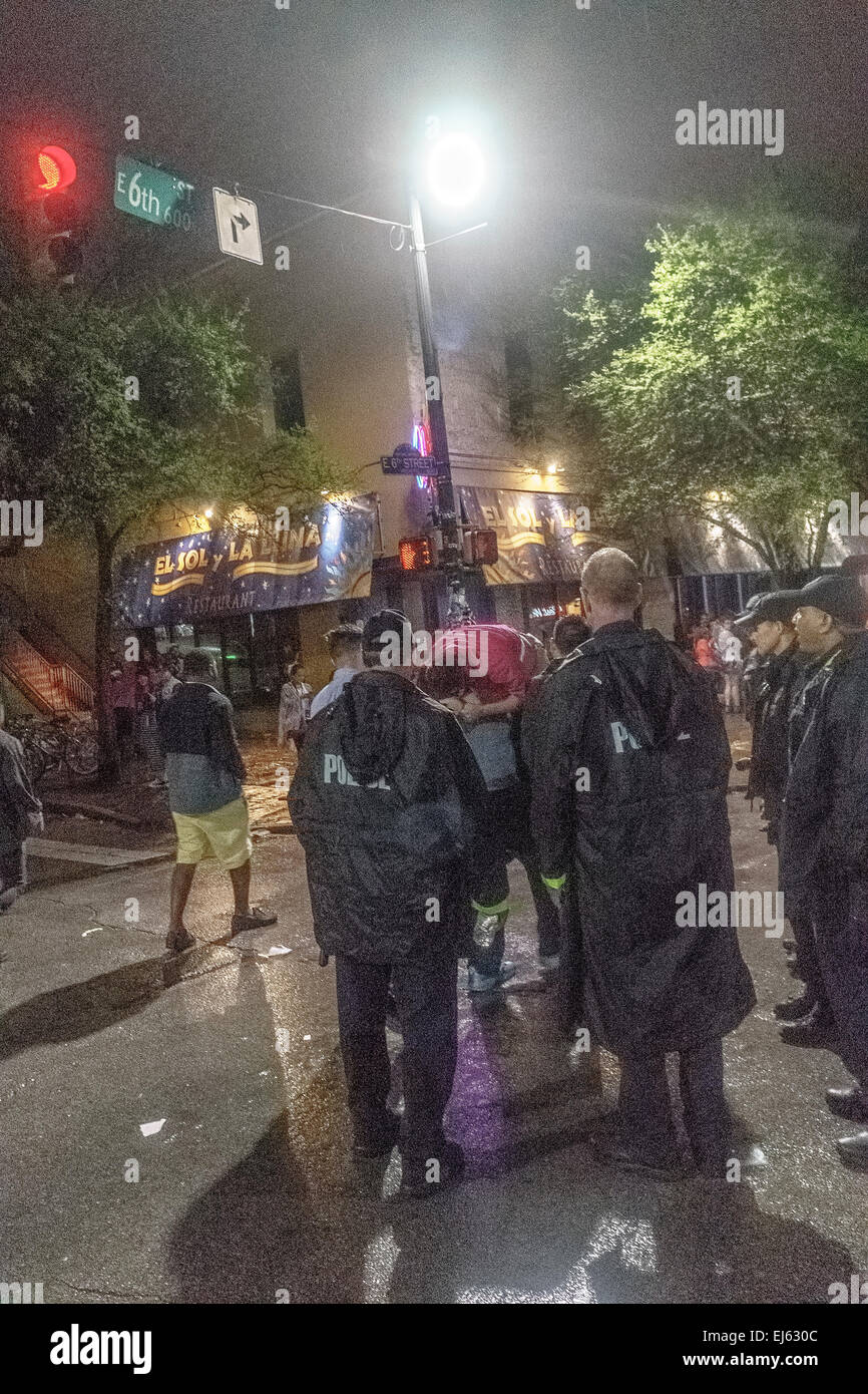 Austin, Texas, USA. 20th Mar, 2015. Police watch friends of person who passed out on 6th street carry him away at SXSW in Austin Texas USA on March 21 2:30 AM 2015 Credit:  Jon-Paul Jones/Alamy Live News Stock Photo