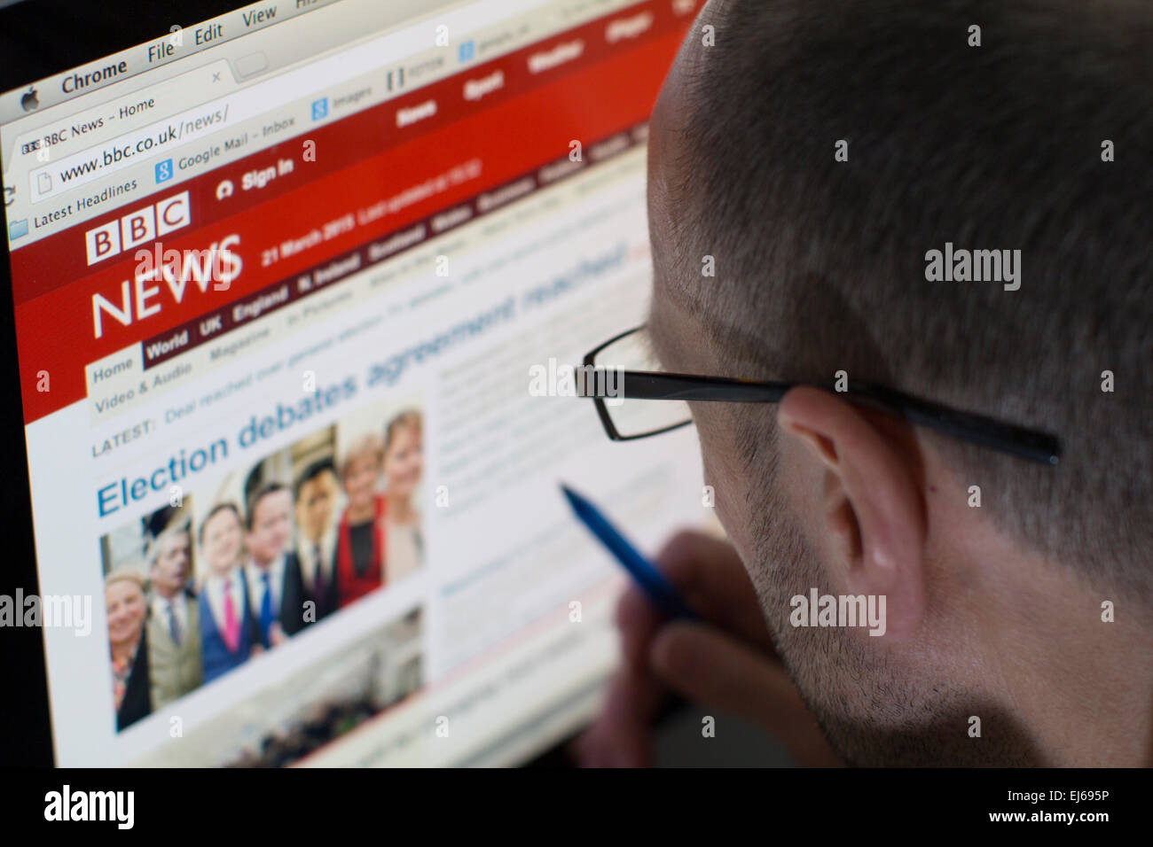 Male looking at the website of bbc news on desktop computer Stock Photo