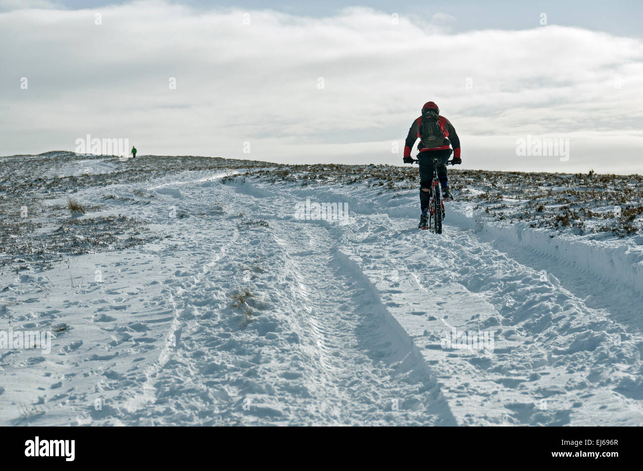 Mountain biker heading towards Win Hill in winter, Peak District, Derbyshire, England, UK. Stock Photo