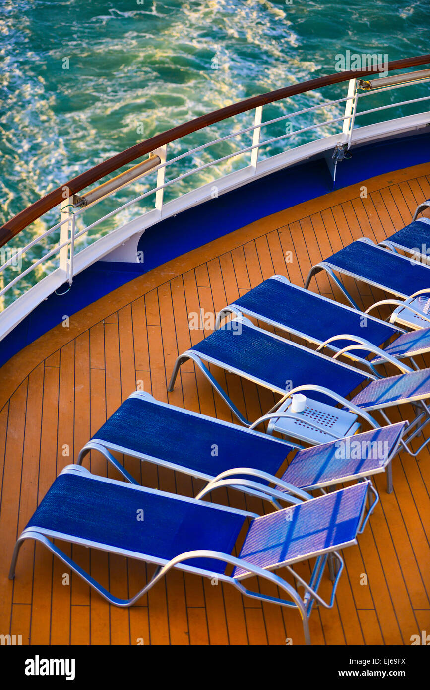Blue sunbeds aligned on the deck Stock Photo