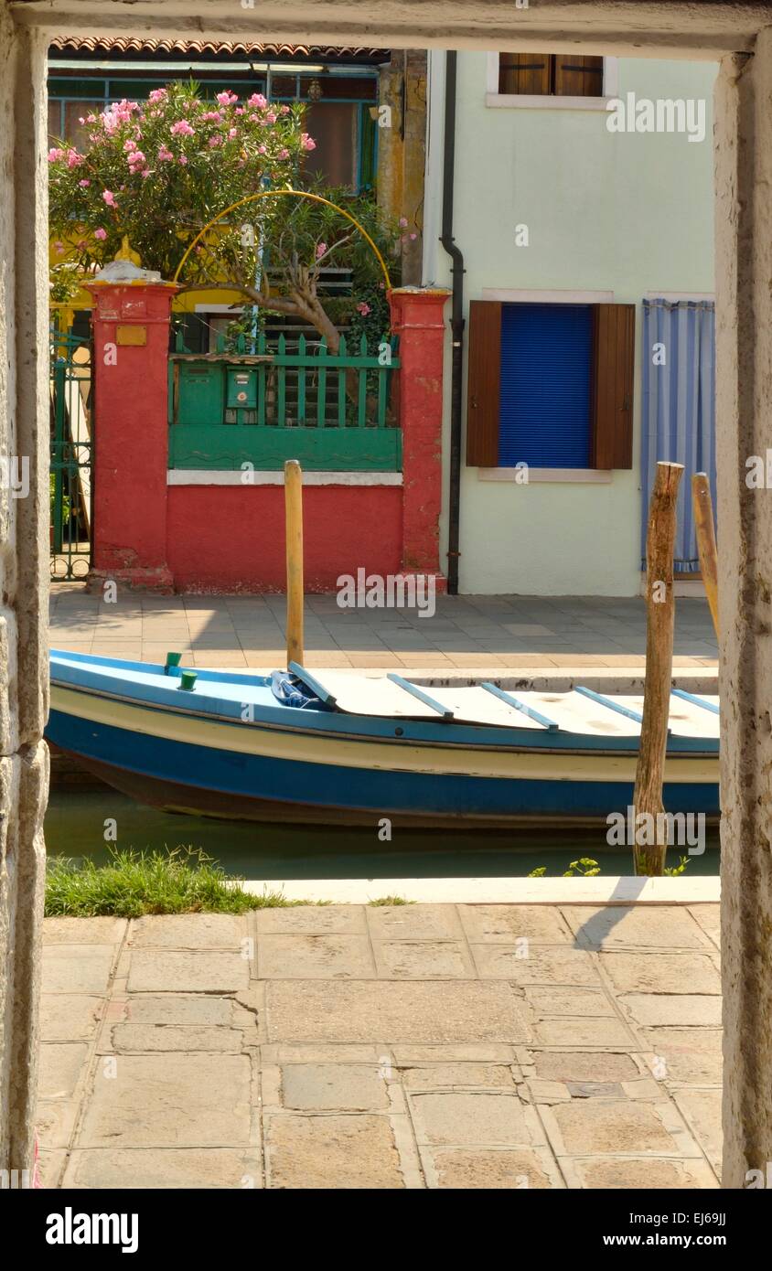 Boat in small canal seen from a street gate in Burano, a fisher island of Venice, Italy Stock Photo