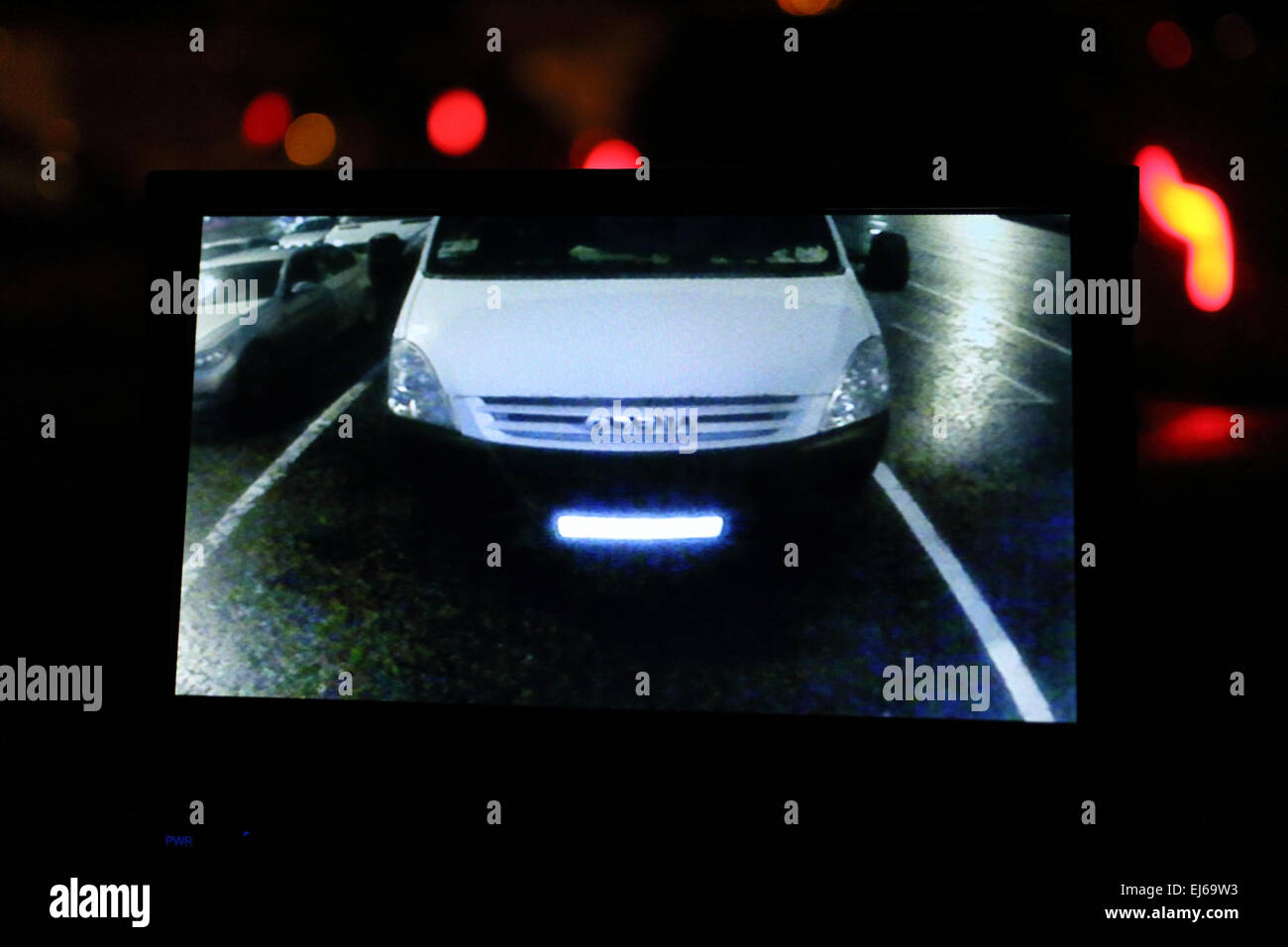 van in rear view camera screen in vehicle dashboard in traffic at night Stock Photo