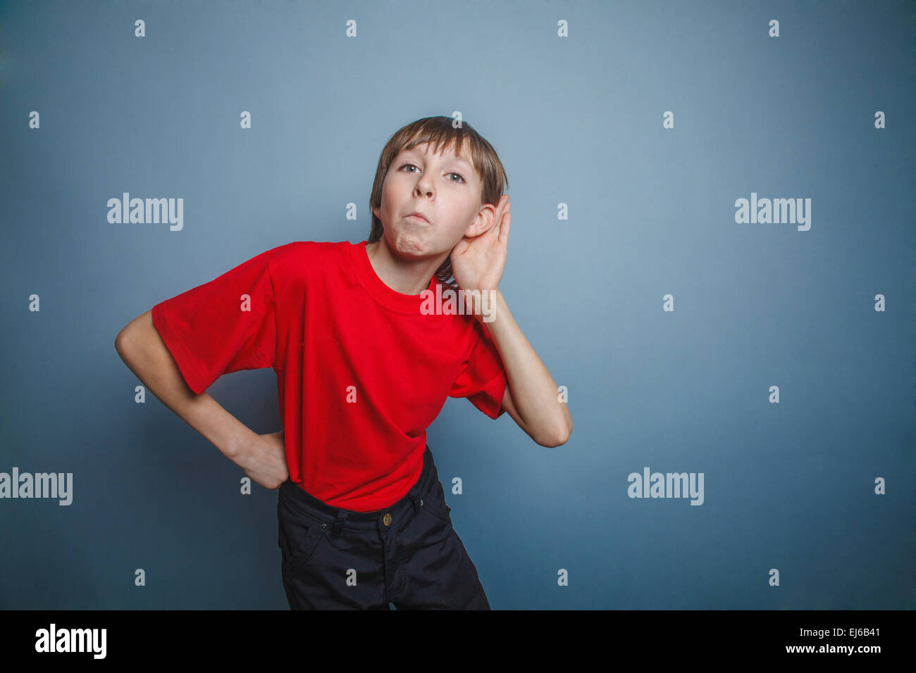 Boy, teenager, twelve years old, in a red shirt, holding hand Stock Photo