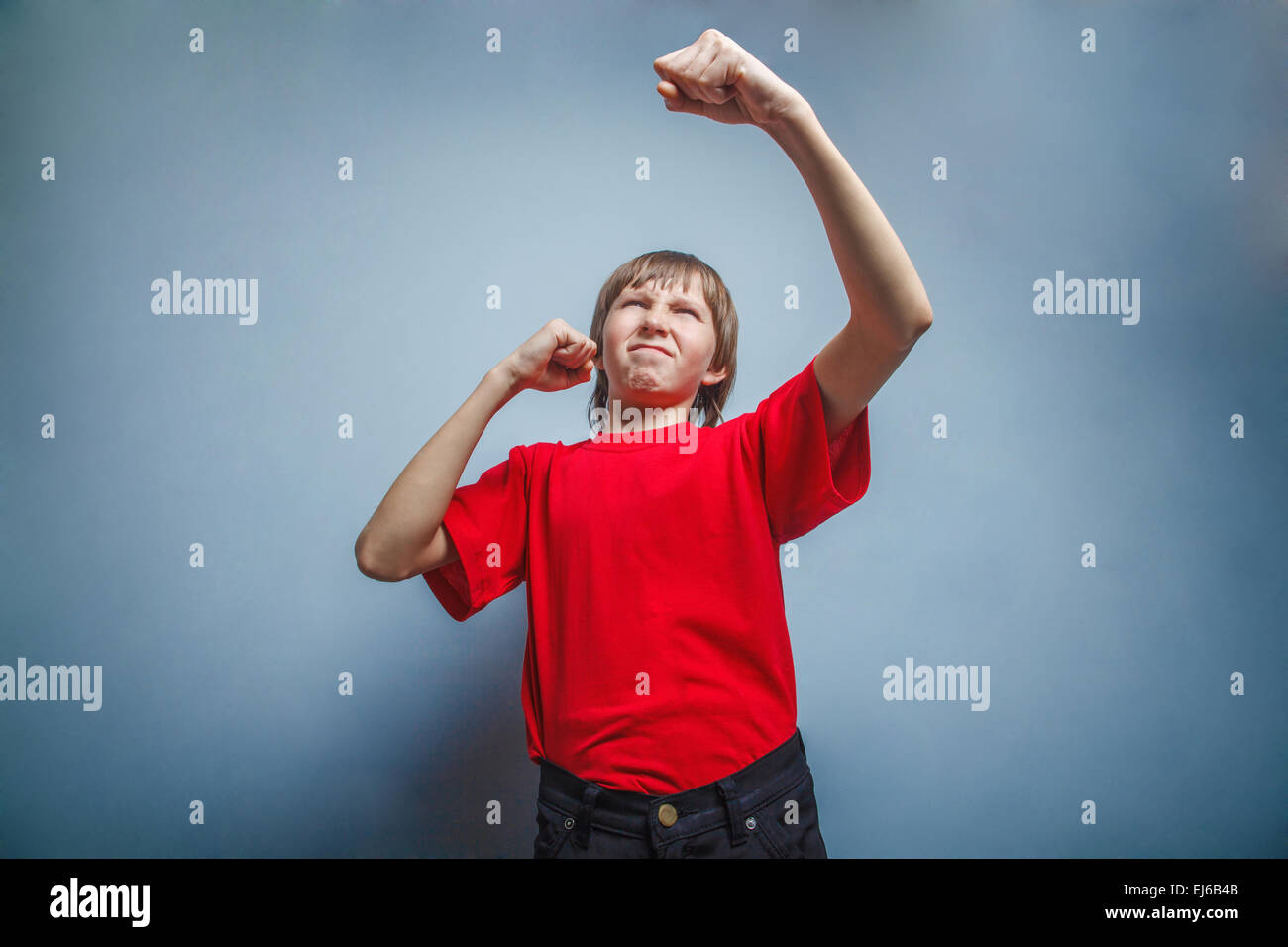 Boy, teenager, twelve years red in shirt, showing fists his Stock Photo