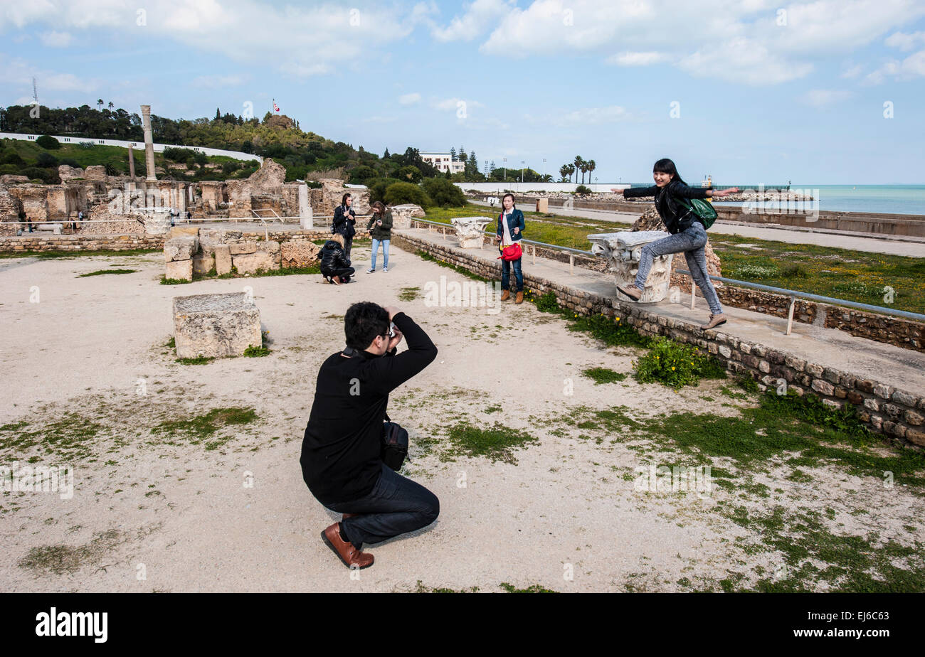 Asian tourists taking snapshots inside the Antonine Bath Complex at Carthage, Tunisia. Stock Photo