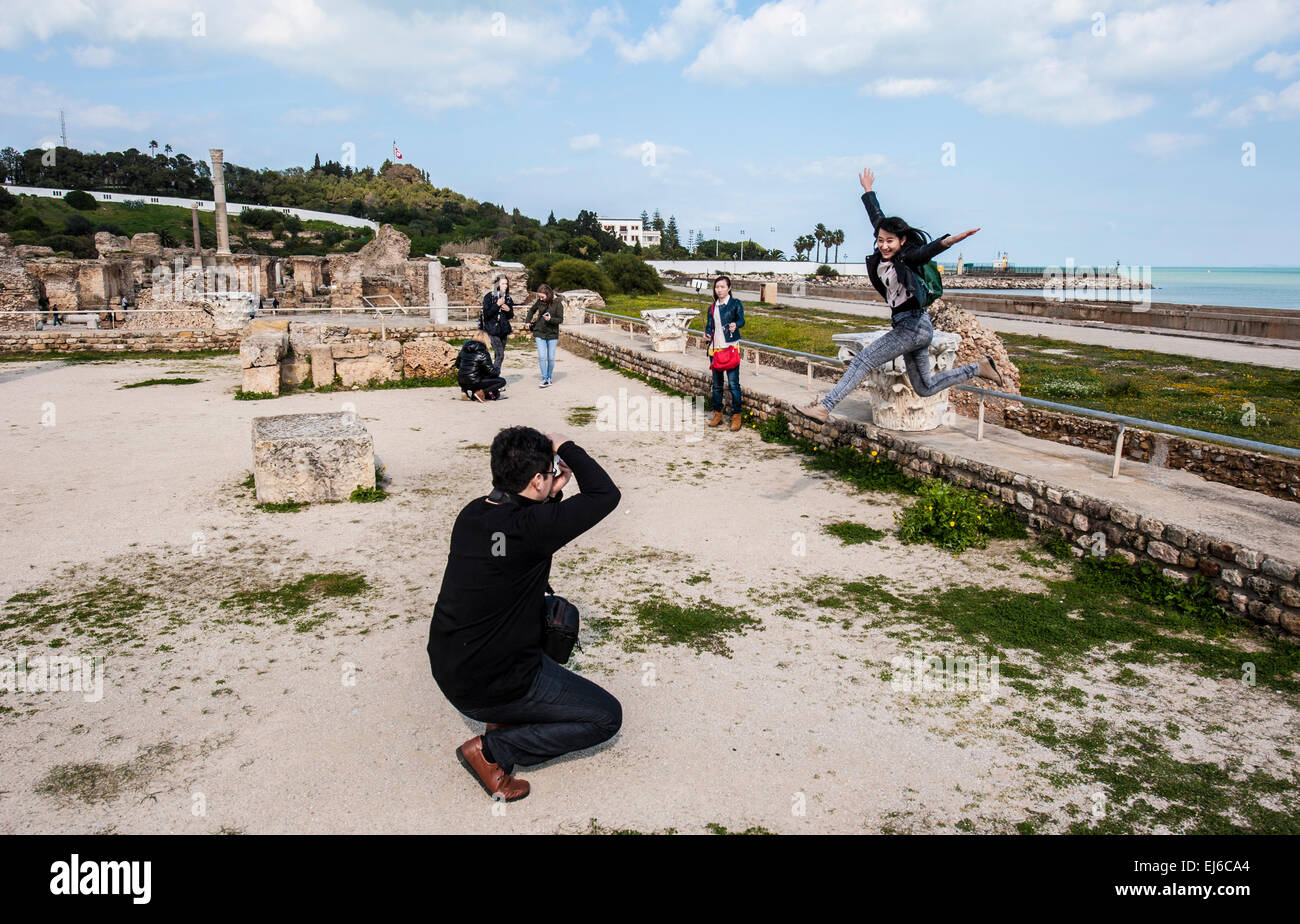 Asian tourists taking snapshots inside the Antonine Bath Complex at Carthage, Tunisia. Stock Photo