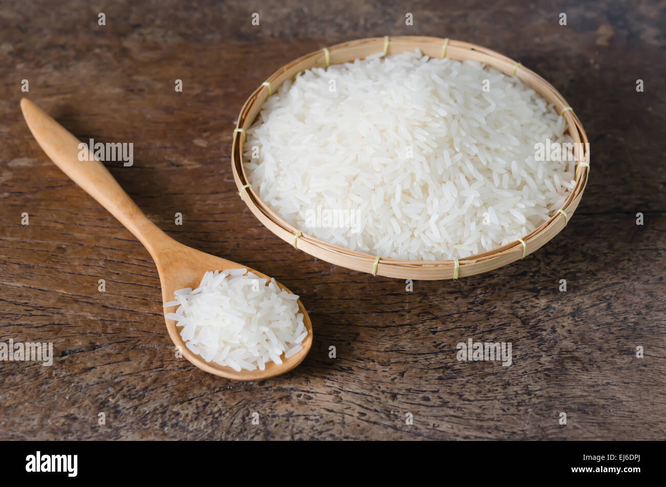 white rice grains with wooden spoon on wooden table Stock Photo - Alamy
