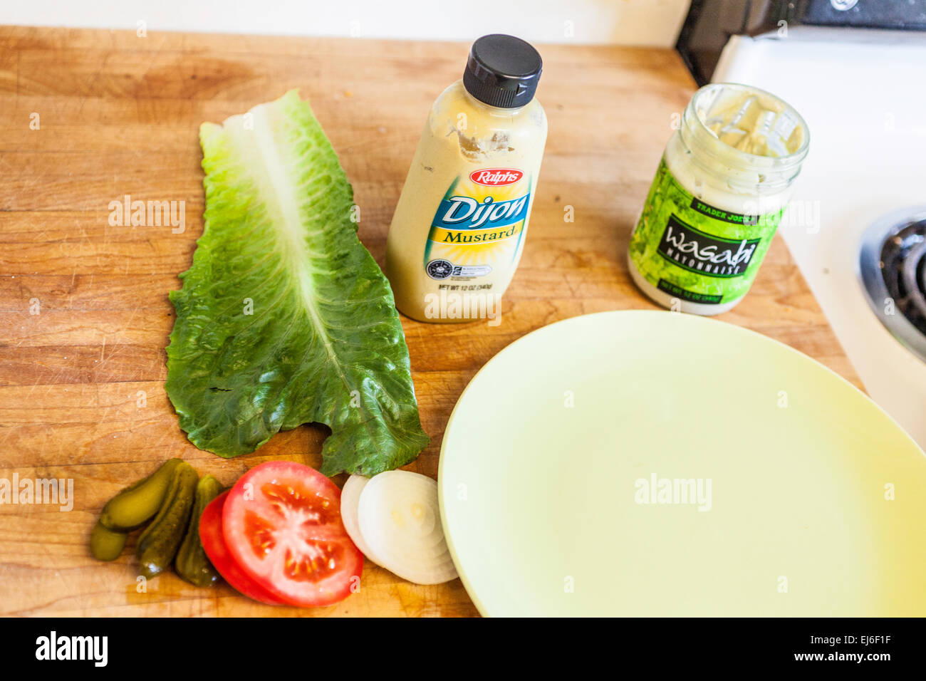 Ingredients for a Hamburger Lettuce Tomato pickles onion mustard and