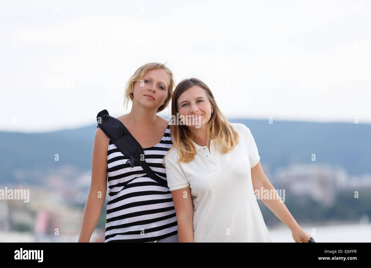 Two attractive young women outdoor. Mountains on blurred background ...