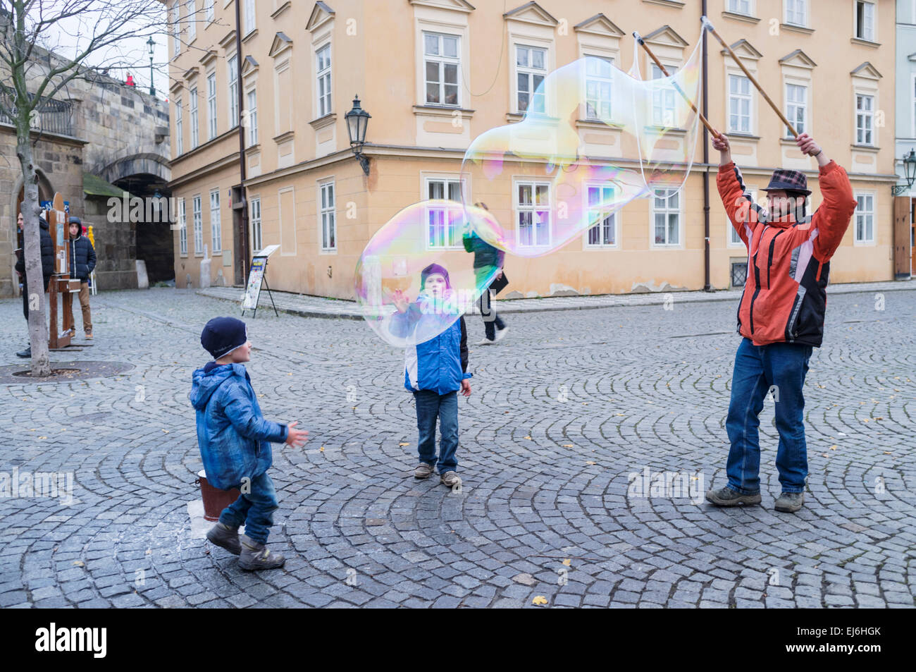 Children and man blowing bubbles in Prague, Czech Republic Stock Photo