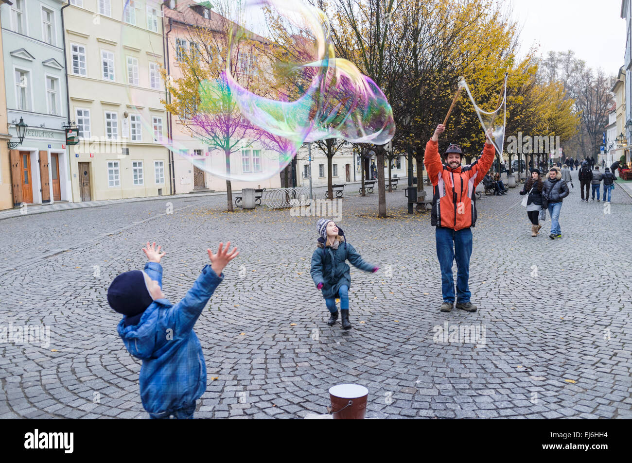 Children and man blowing bubbles in Prague, Czech Republic Stock Photo