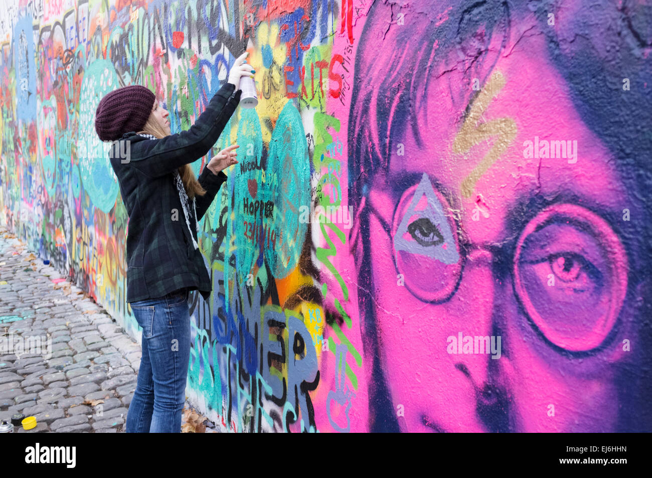 Painting graffiti at the John Lennon Wall. Prague, Czech Republic Stock Photo