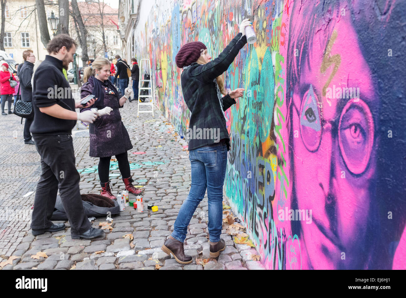 Painting graffiti at the John Lennon Wall. Prague, Czech Republic Stock Photo
