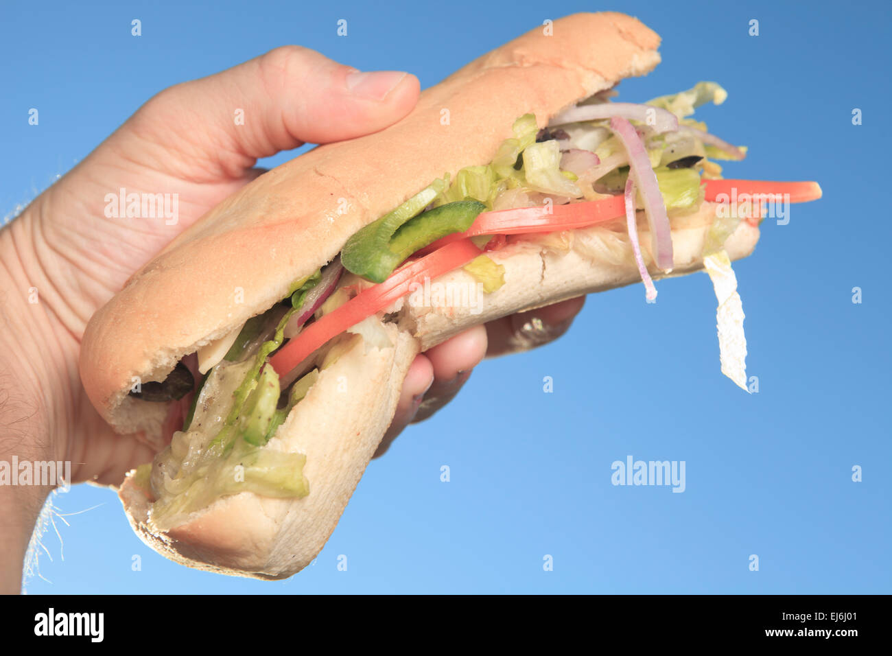 Hand holding sandwich with ham and tomato slices Stock Photo Alamy