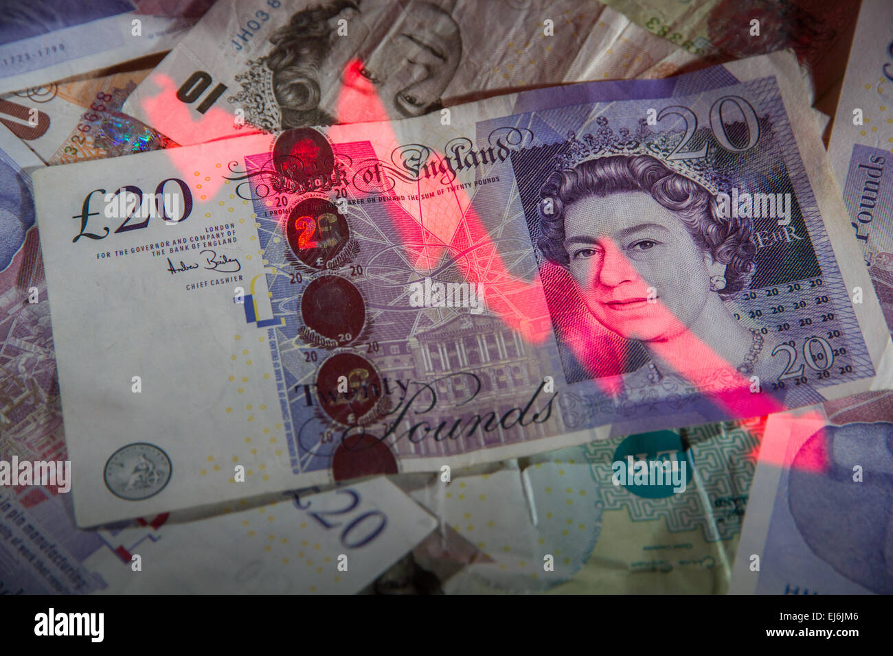 A negative graph projected onto a pile of British banknotes. Stock Photo