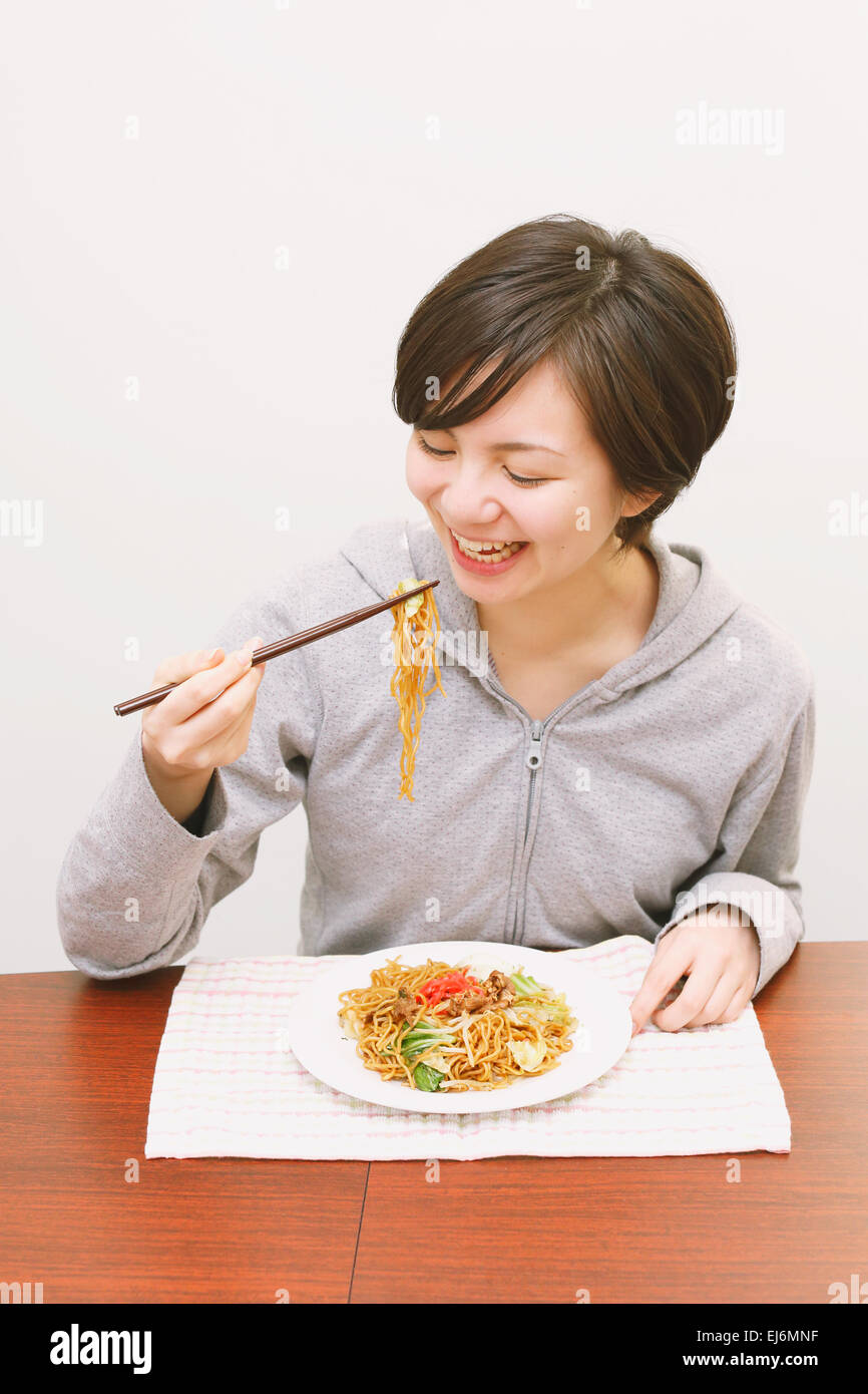 Young Japanese woman eating yakisoba noodles Stock Photo