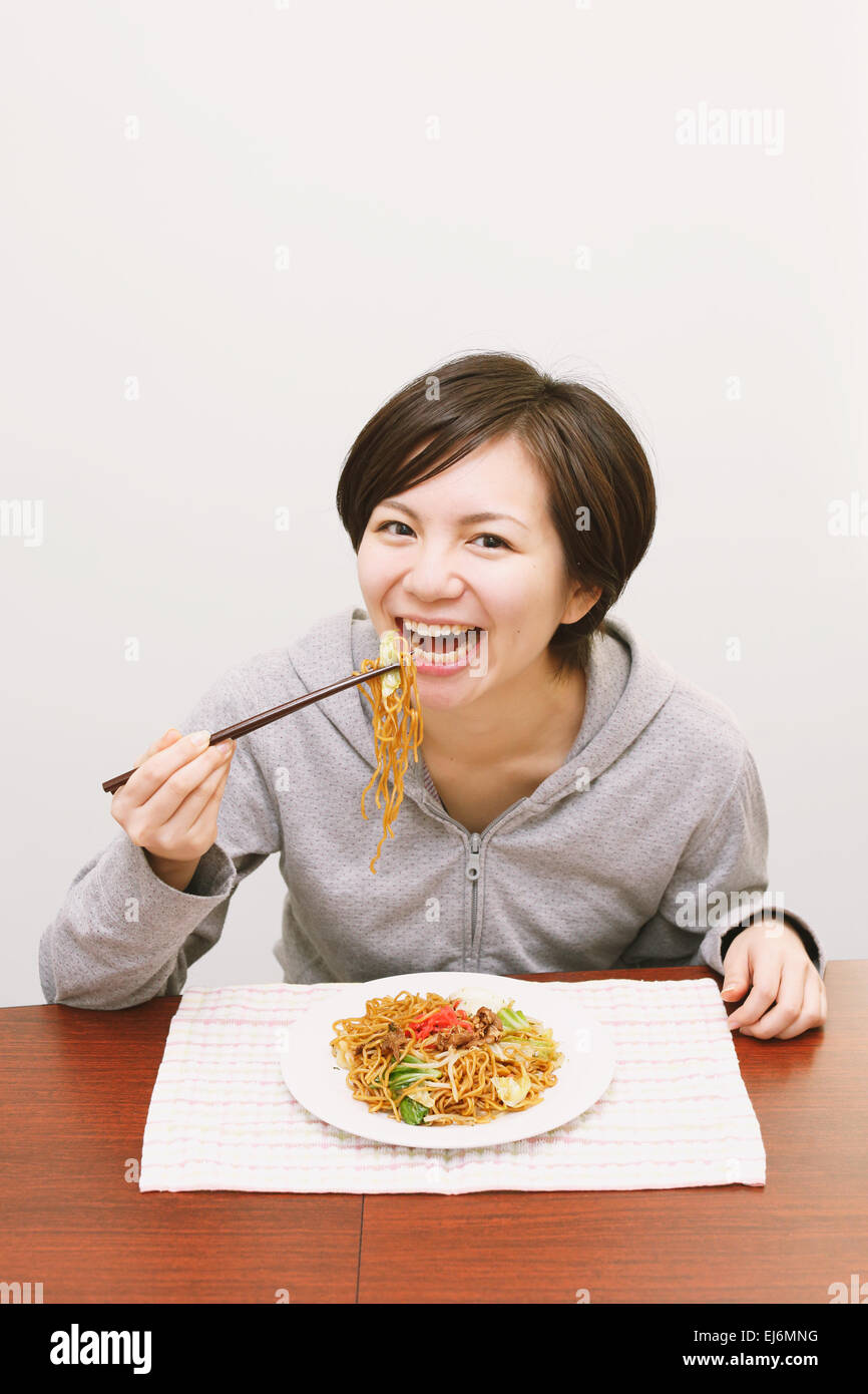 Young Japanese woman eating yakisoba noodles Stock Photo