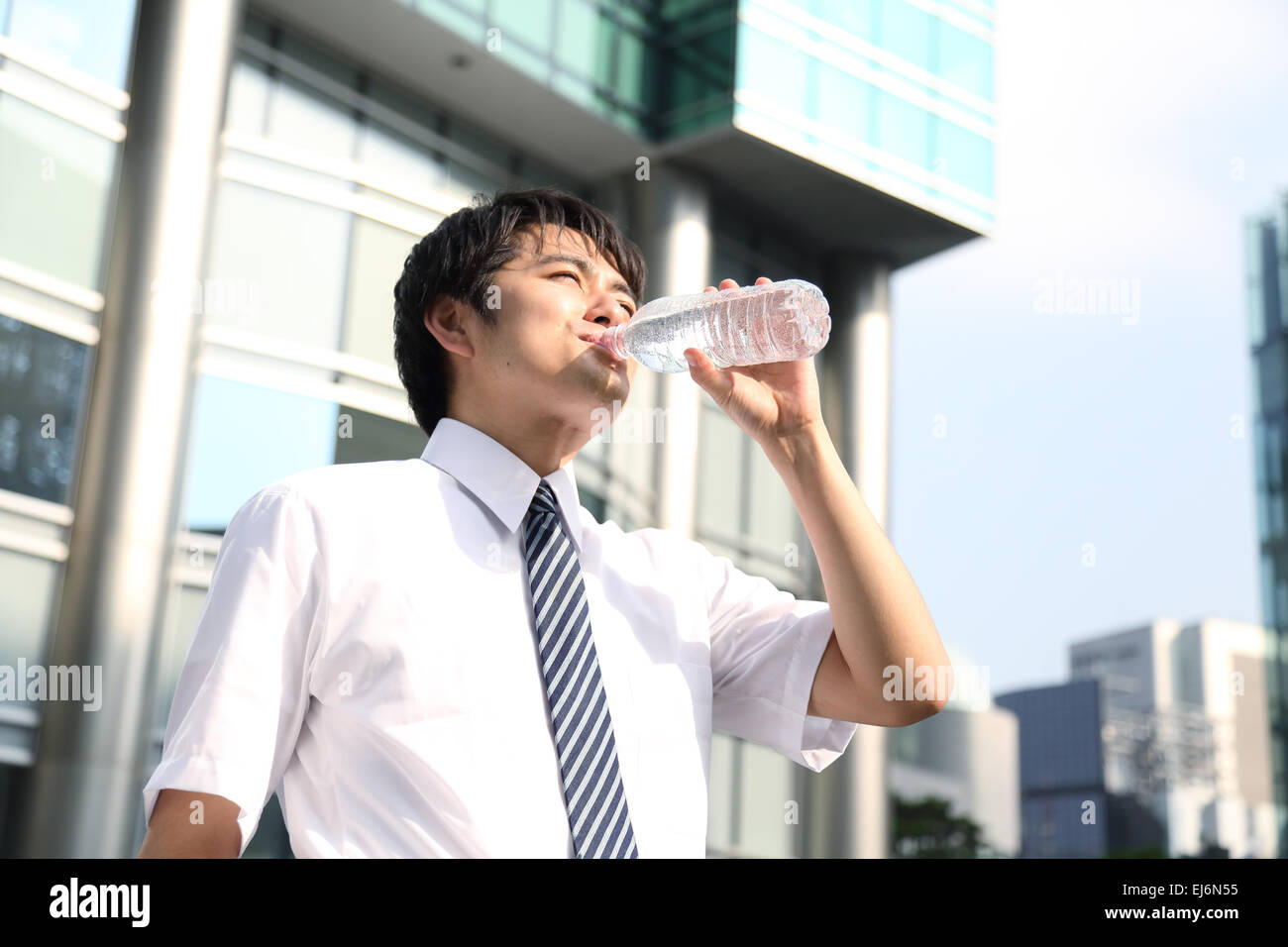 Japanese businessman drinking water in the hot Japanese Summer Stock