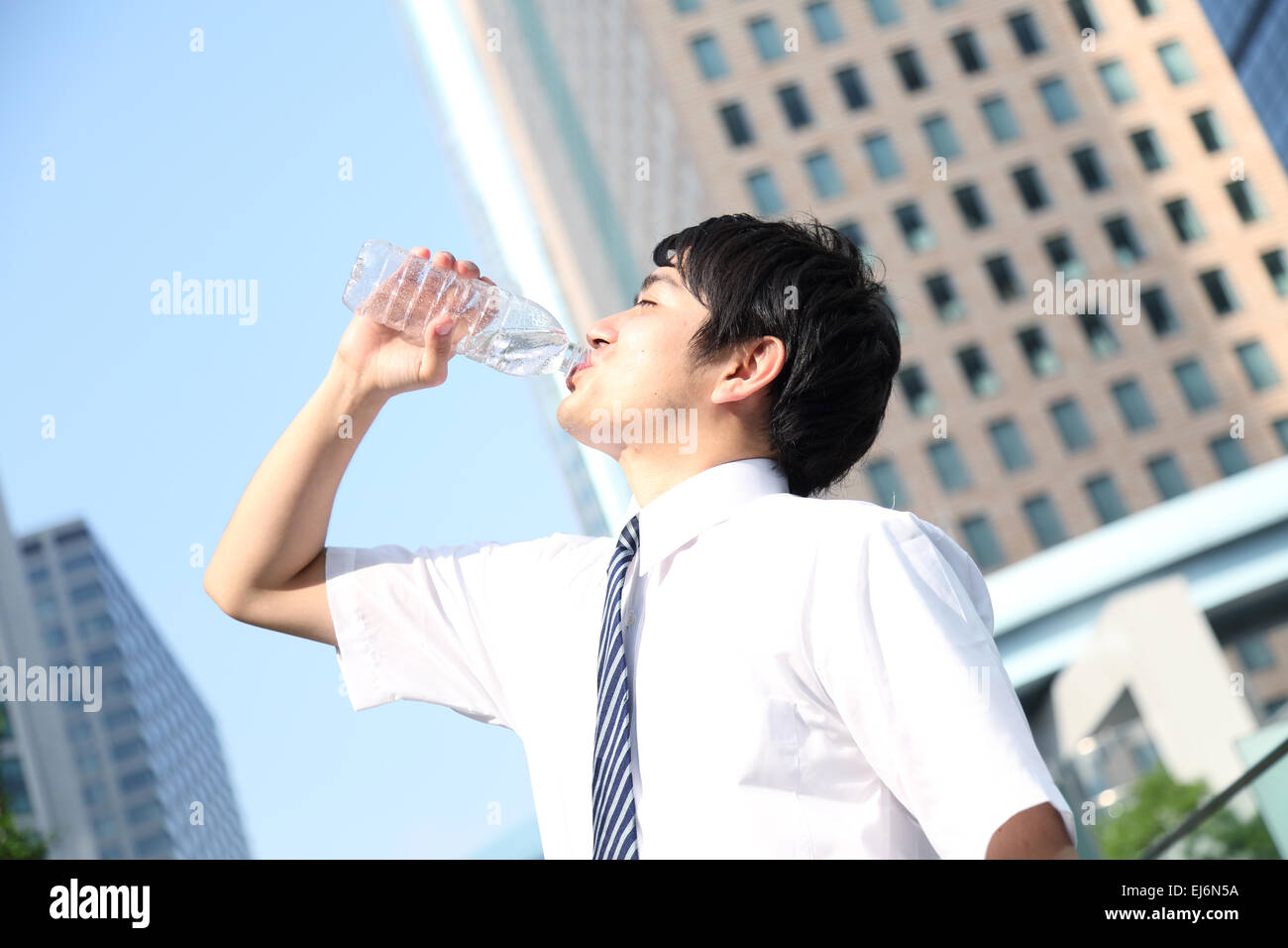 Japanese businessman drinking water in the hot Japanese Summer Stock
