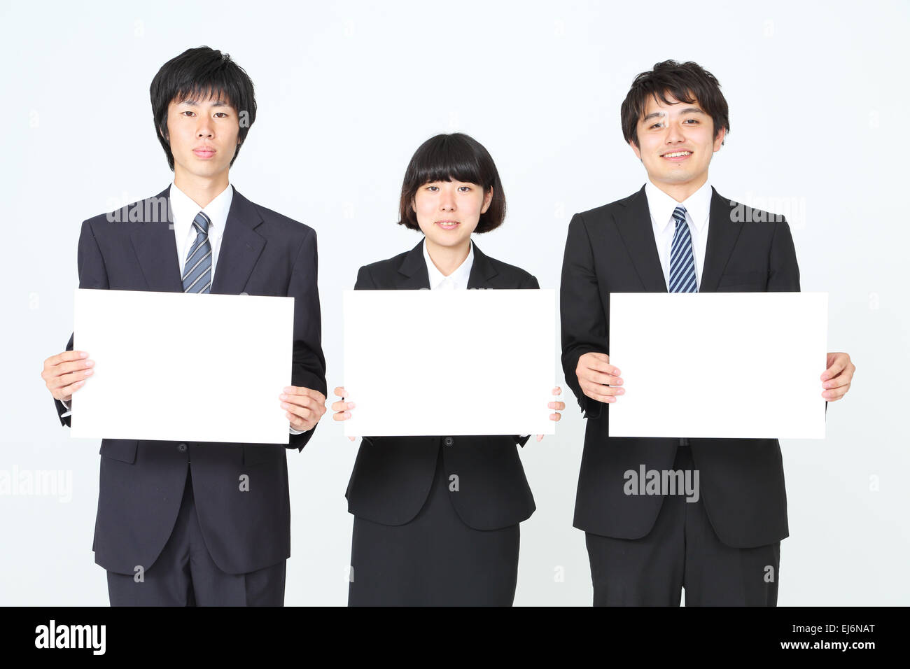 Young Japanese business people holding white boards Stock Photo